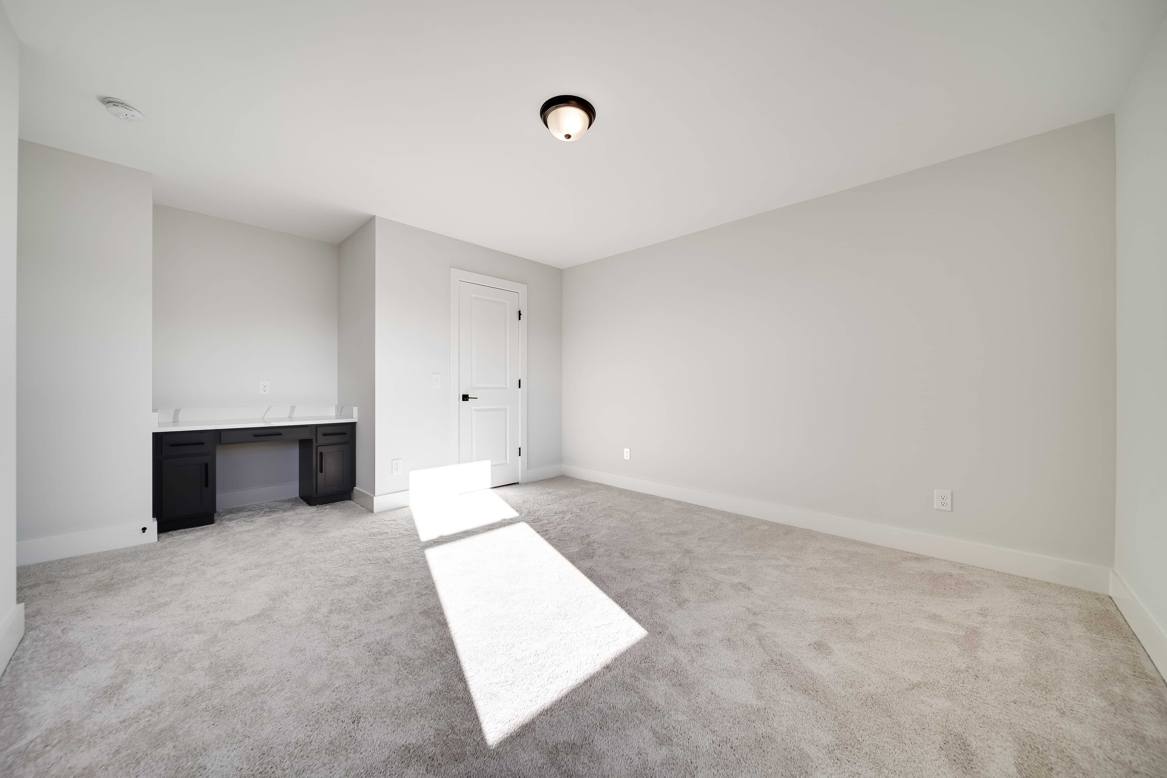 Modern Room with Built-In Desk in Richvale Estates Bright, minimalist room with built-in desk and neutral walls in Richvale Estates community.