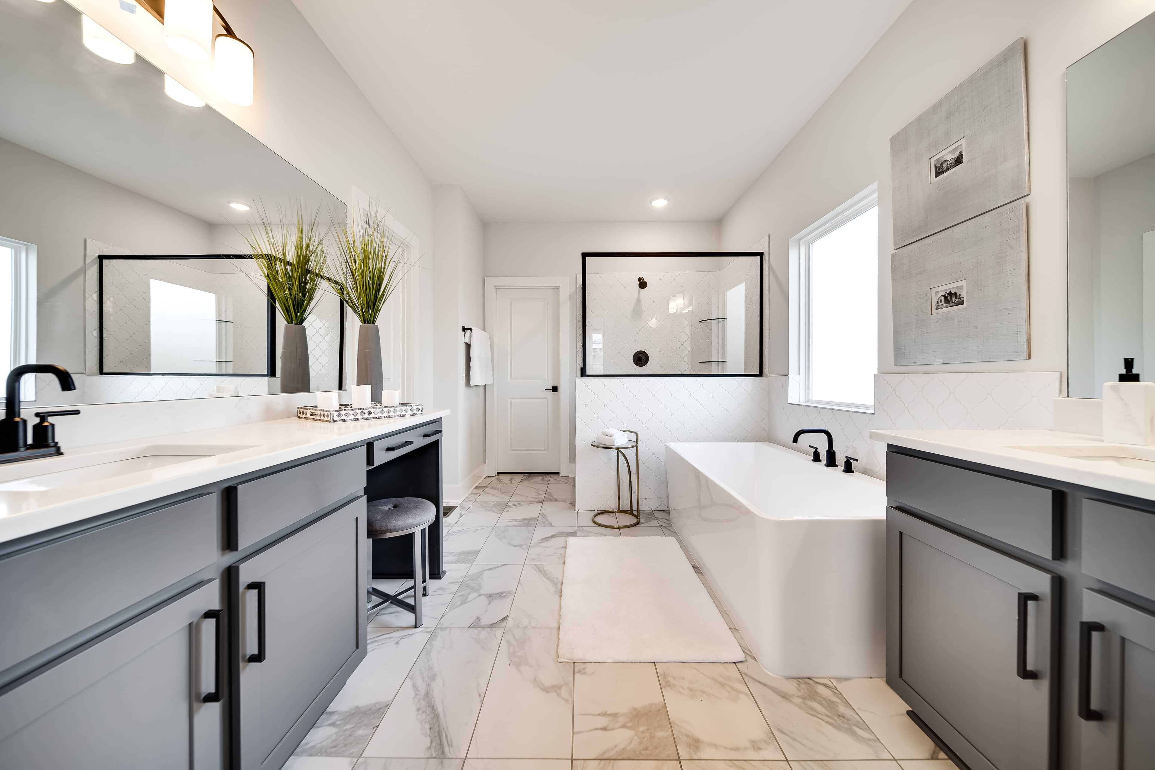 Richvale Estates Luxury Bathroom with Marble Floors and Modern Design Luxurious bathroom in Richvale Estates, features gray cabinets, marble floor, modern tub, glass shower.