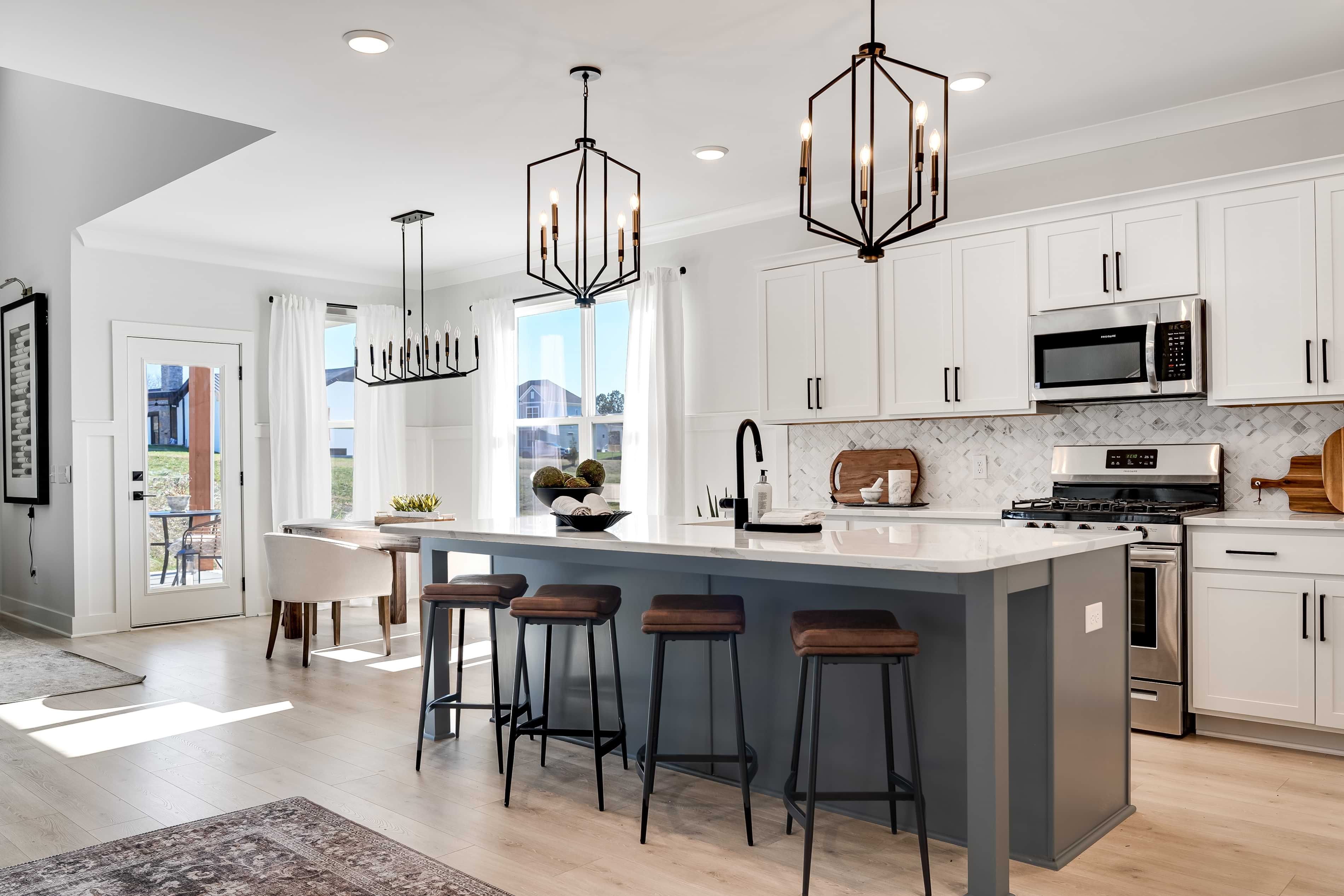 Modern Kitchen with Island in Richvale Estates Modern kitchen with large island, pendant lights, white cabinets, and patio door. Richvale Estates community.