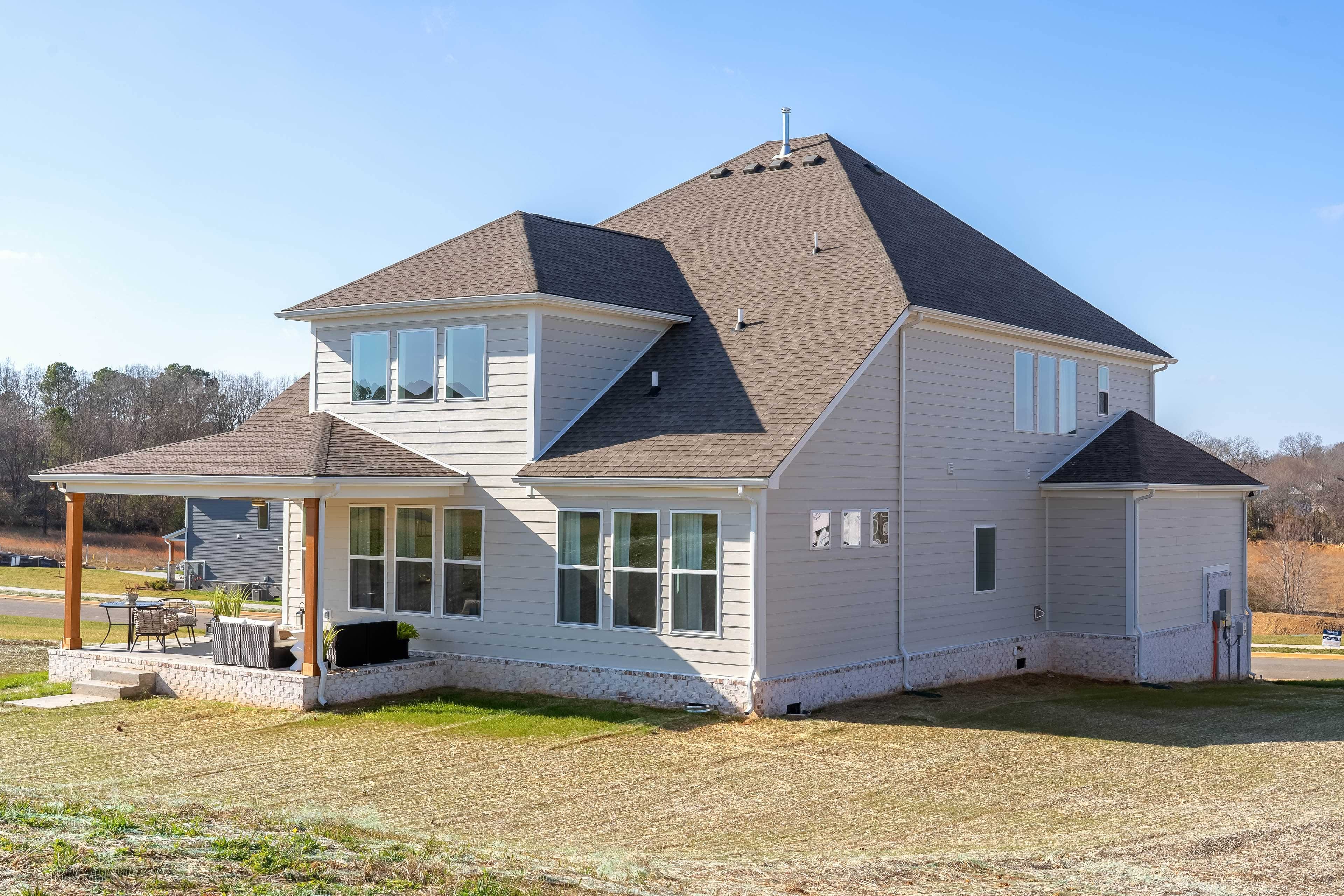 Two-story Modern House with Gable Roof in Richvale Estates Modern two-story house with gable roof, large windows, and patio in Richvale Estates community, surrounded by greenery.