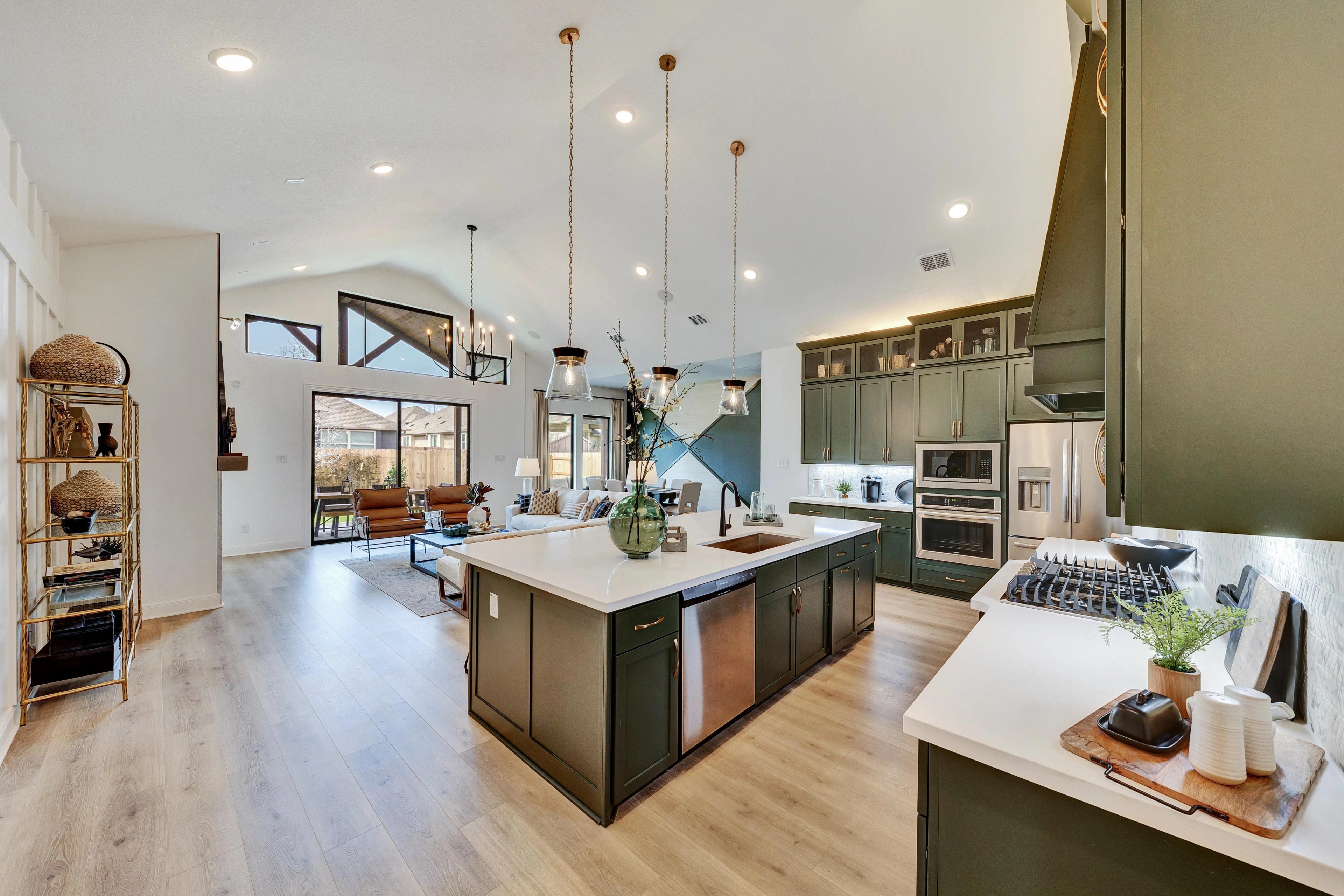 Elegant Kitchen Design with Green Cabinets in Hawkes Landing Home Spacious kitchen in Hawkes Landing, featuring green cabinets, pendant lights, island, and airy open layout.