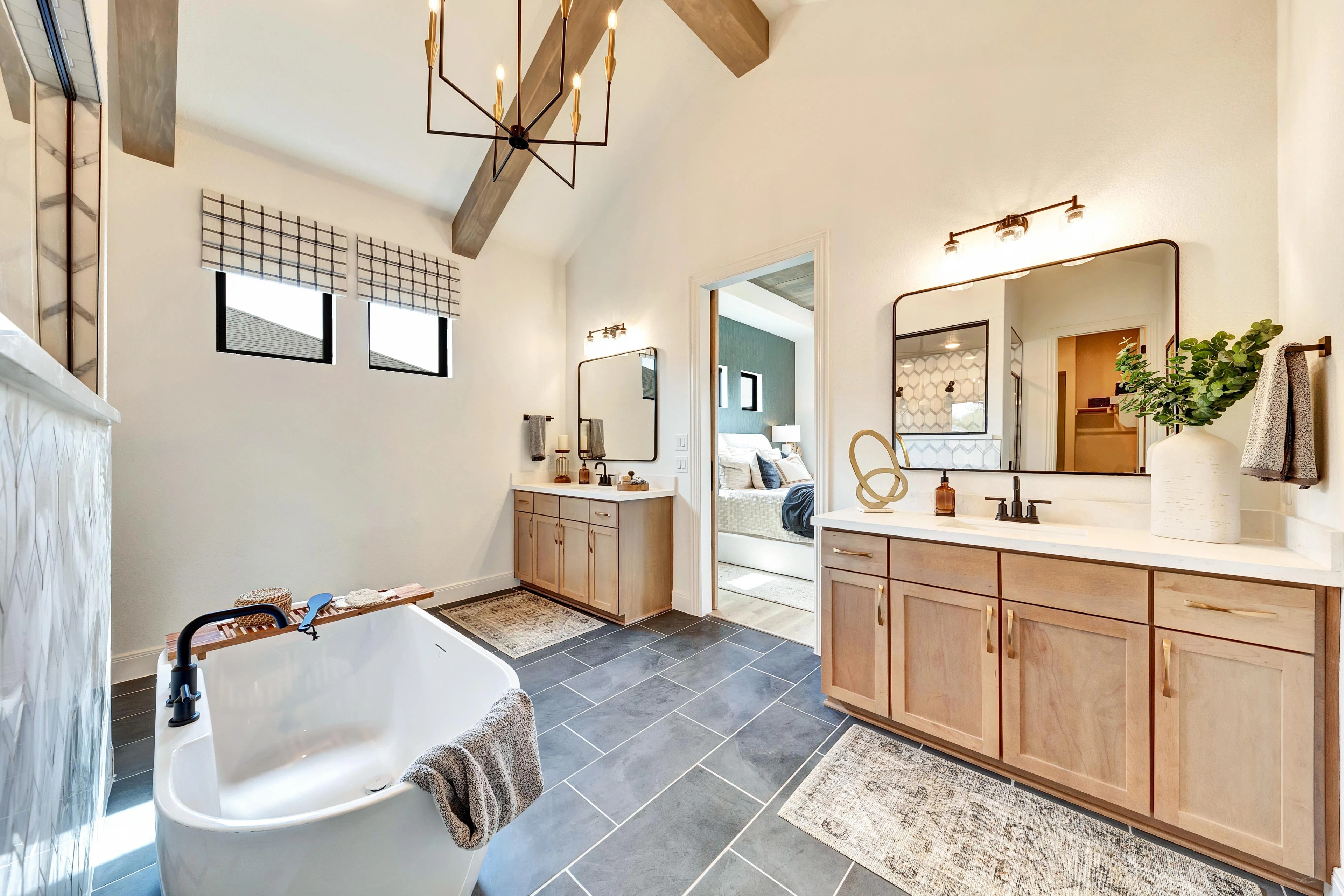 Luxurious Bathroom Design in Hawkes Landing with Freestanding Tub Luxurious bathroom with freestanding tub, wood vanity, large mirrors, modern lighting, and tile floor in Hawkes Landing.