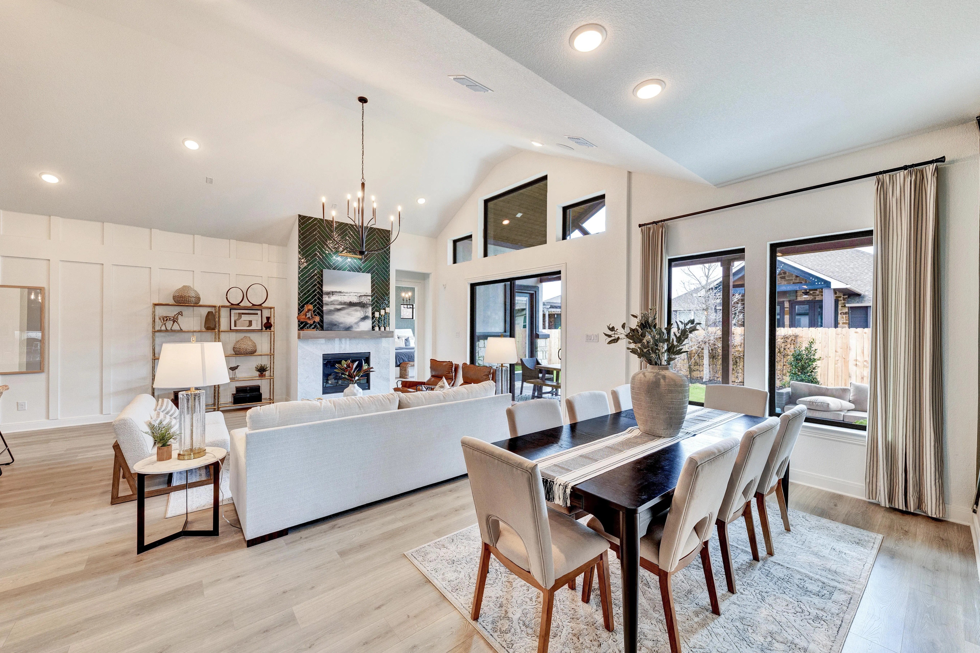 Elegant Living Room with Fireplace and Vaulted Ceiling in Hawkes Landing Spacious living room with vaulted ceiling, modern fireplace, large windows, Hawkes Landing, luxury design.