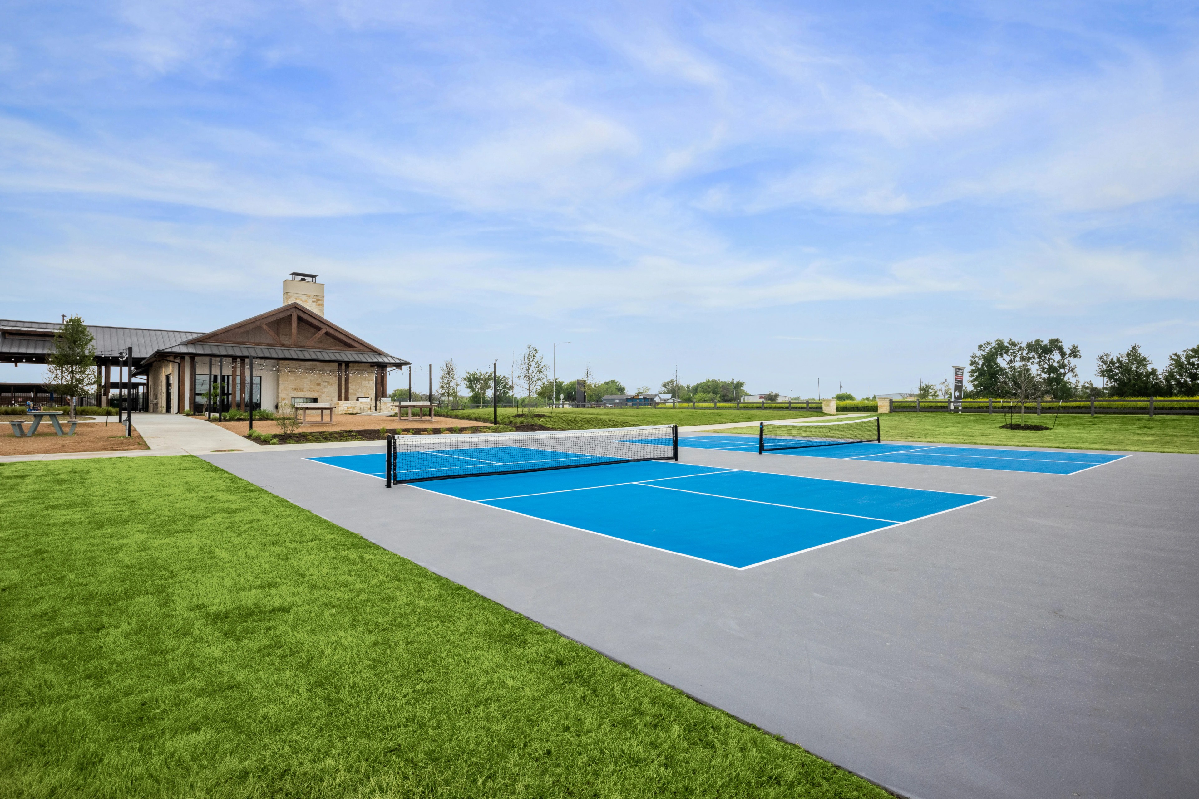 Tennis Court and Clubhouse at Carillon Community, Texas Tennis court and clubhouse with brick facade and metal roof at Carillon community, Texas.