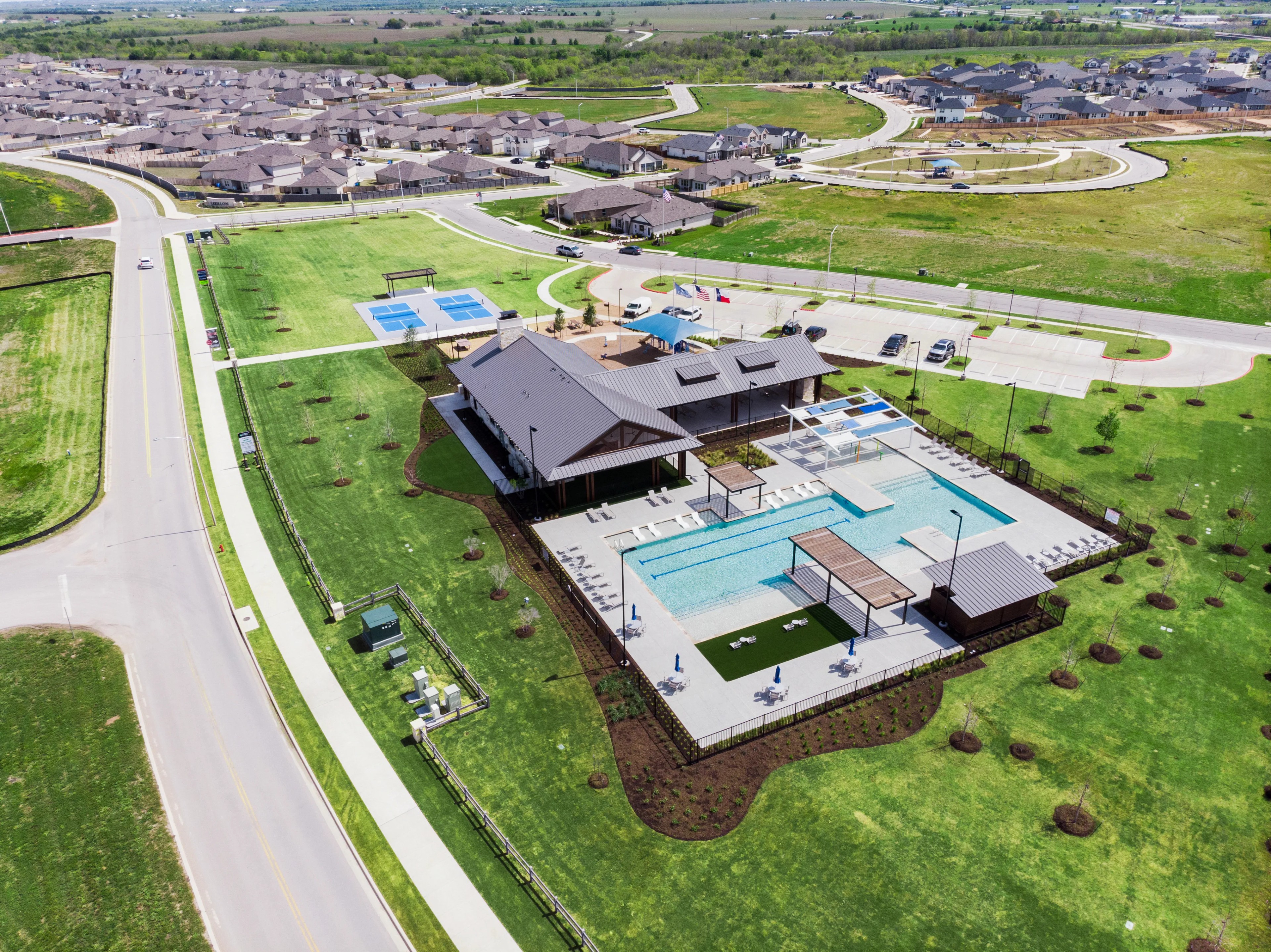 Carillon Community Clubhouse with Pool in USA Aerial View Aerial view of Carillon community clubhouse with modern pool, tennis courts, lush landscaping in USA. Residential background.