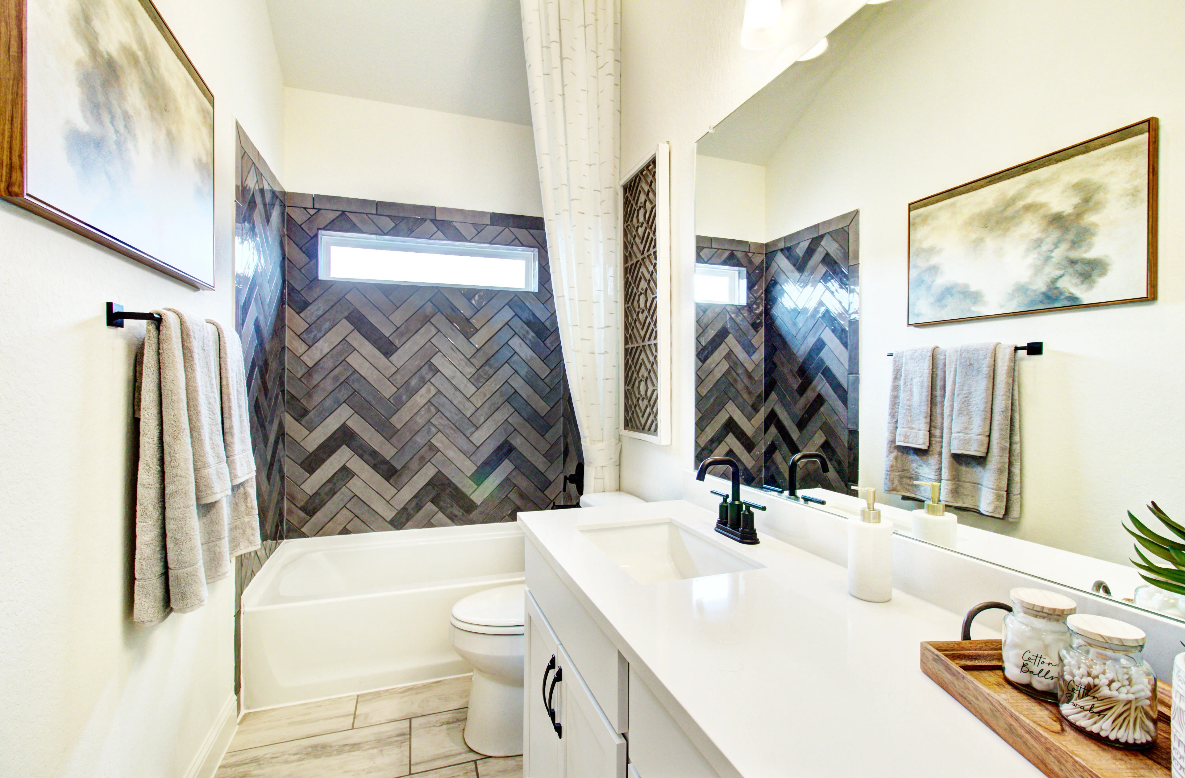 Elegant Herringbone Tile Bathroom in Veranda Community Modern bathroom with herringbone tile, sleek fixtures, and large mirror in Veranda community.
