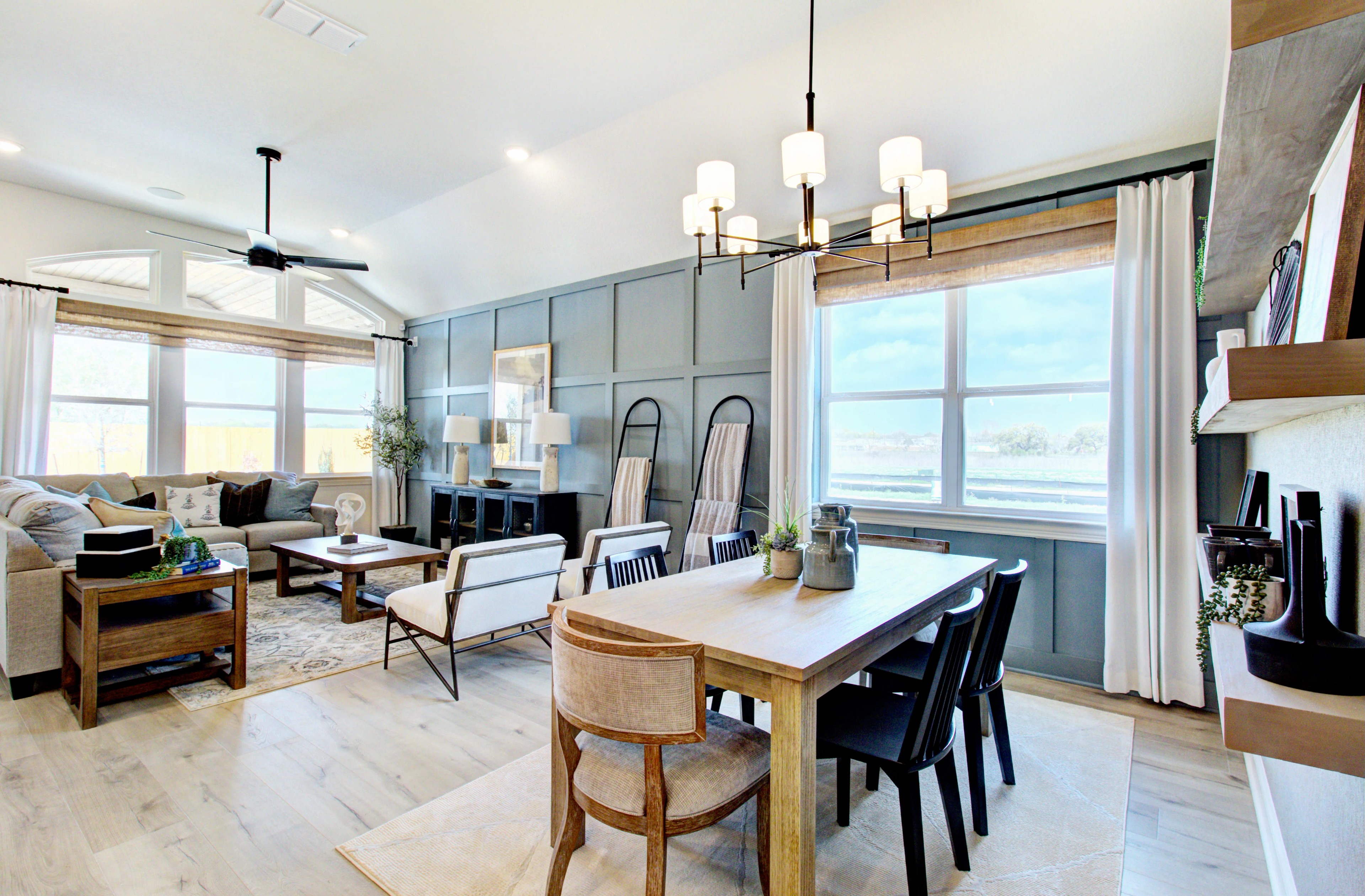 Veranda Community Living-Dining Space with Vaulted Ceiling Luxurious living-dining area with vaulted ceiling, large windows, elegant chandelier, in Veranda community.