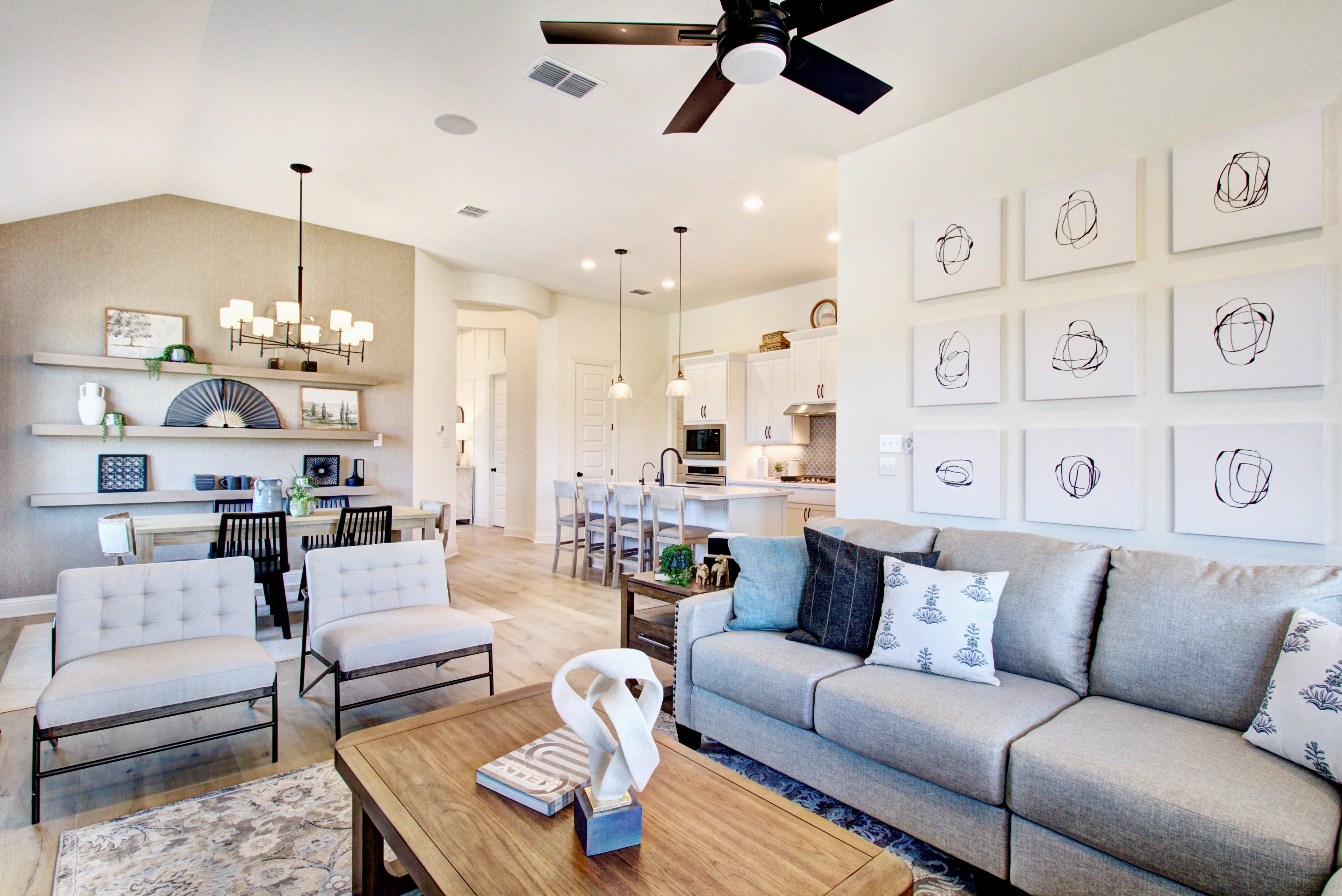 Modern Living Room with Art Wall in Veranda Community Modern open-concept living room, Veranda community. Features art wall, sleek kitchen, and stylish lighting.