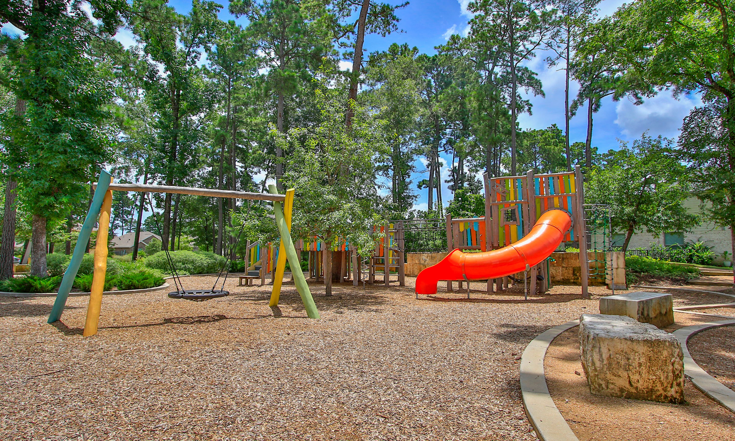 Playground in The Woodlands Hills, Texas with Swings and Slide Vibrant playground in wooded area with swings, slide in The Woodlands Hills, Texas, showcasing natural surroundings.