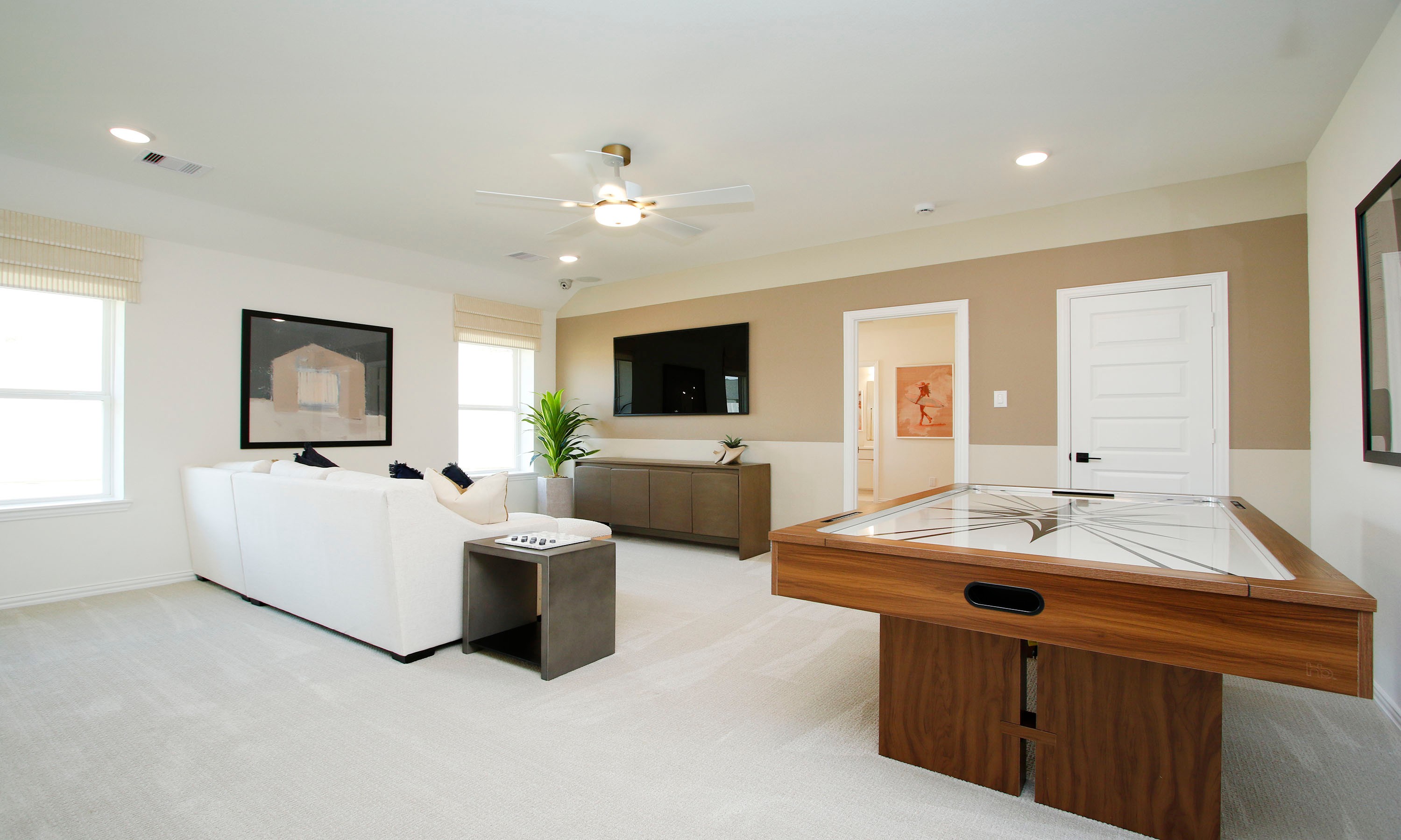 Elegant Living Room with Game Table in The Woodlands Hills Luxury living room in The Woodlands Hills with modern furnishings, game table, neutral tones, and large windows.