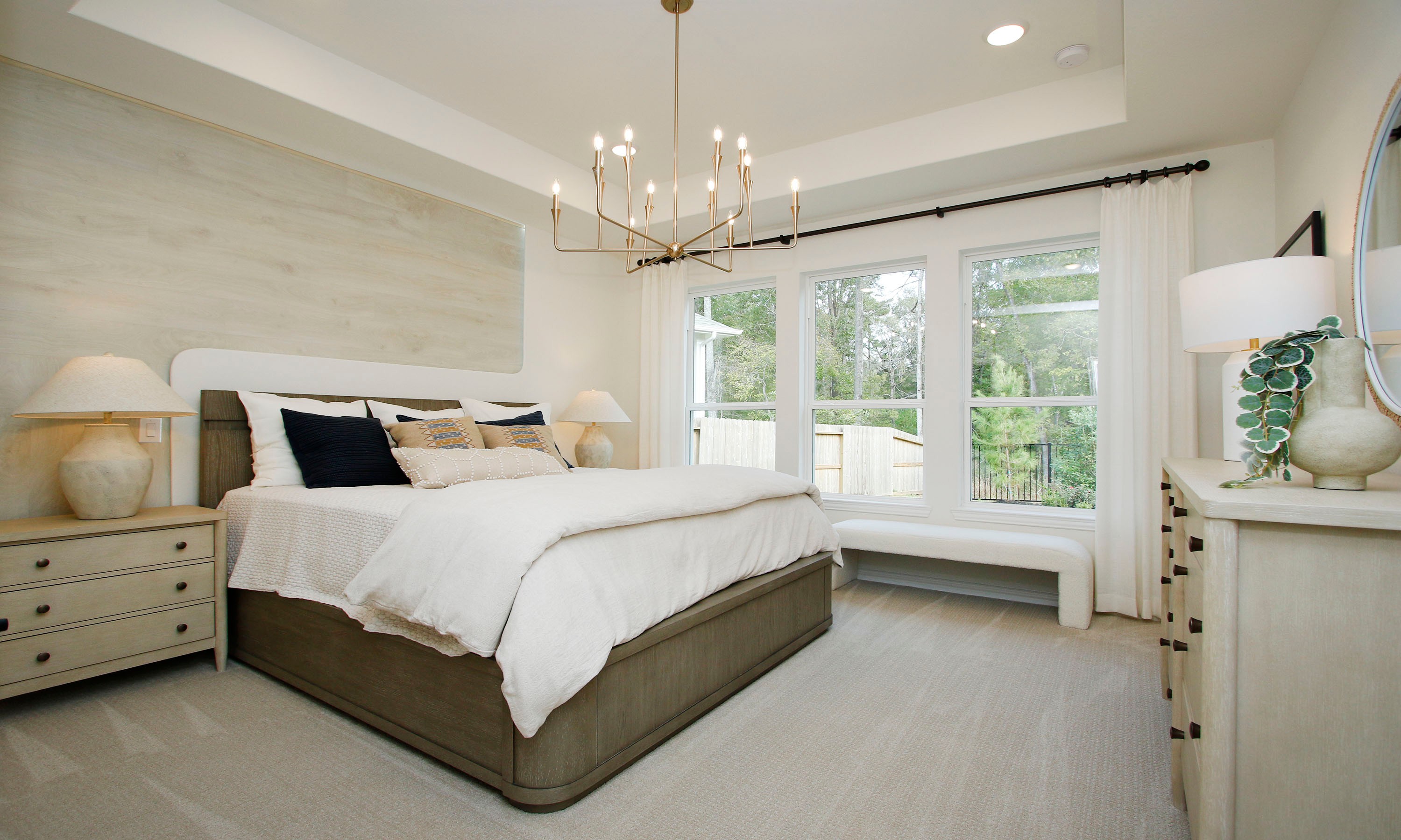 Luxury Bedroom Design in The Woodlands Hills with Large Windows Elegant bedroom with chandelier, large windows, neutral decor in The Woodlands Hills.