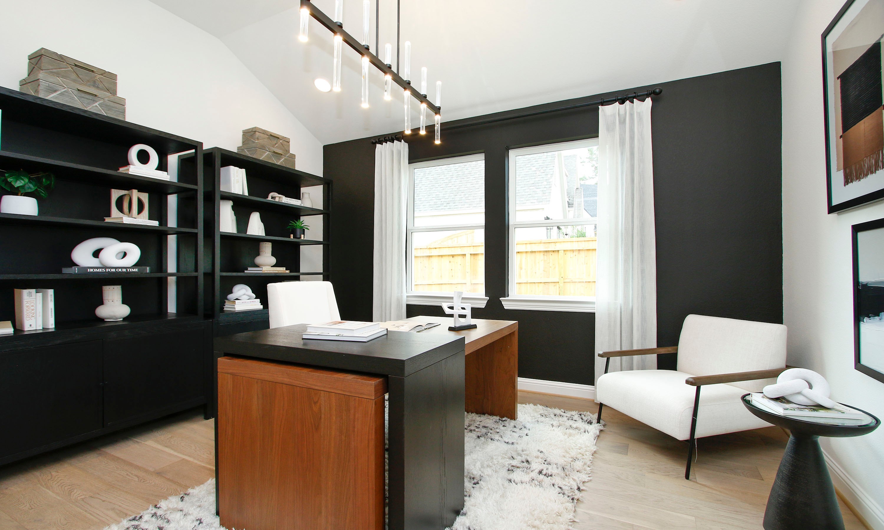 Modern Home Office with Black Shelves in The Woodlands Hills Modern home office in The Woodlands Hills with sleek black shelves, wood desk, and large windows.