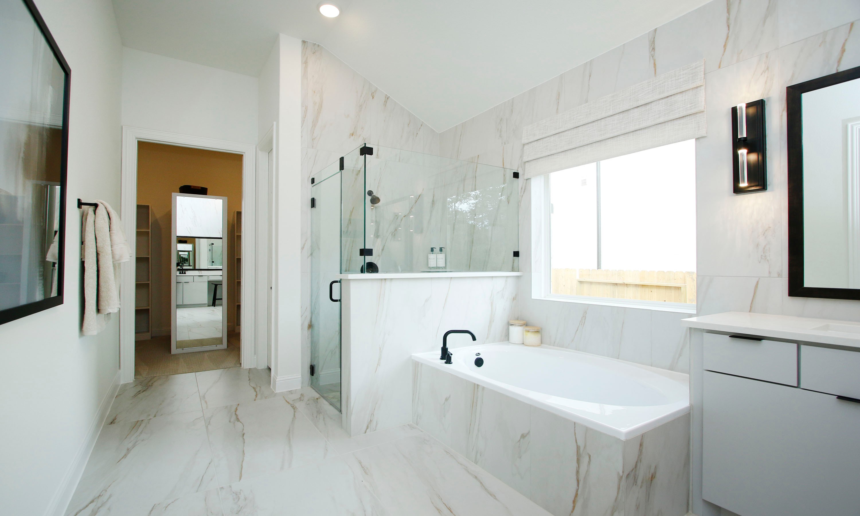 Woodlands Hills Marble Bathroom with Glass Shower and Tub Luxurious Woodlands Hills bathroom with marble tiles, glass shower, large tub, and modern fixtures, featuring natural light.