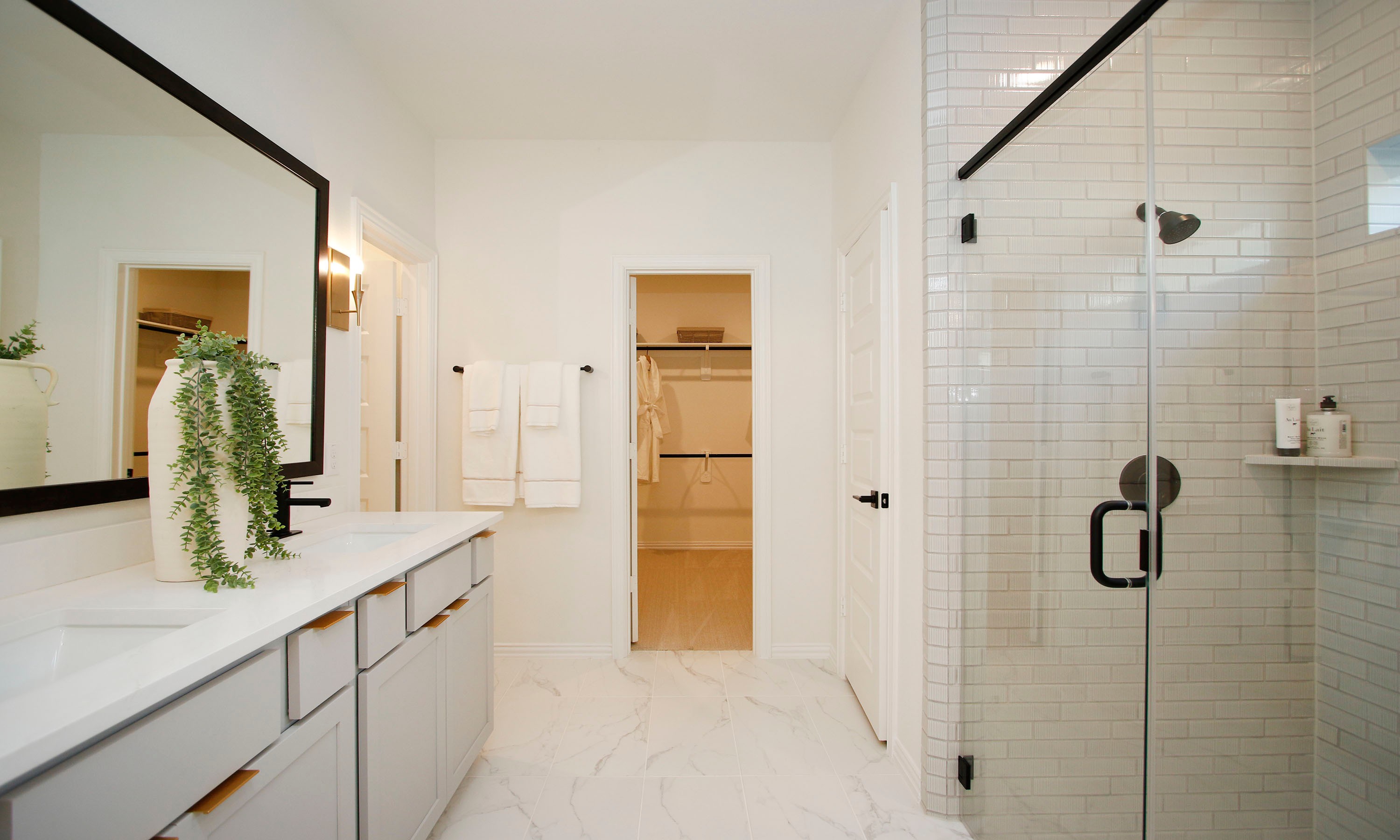 Elegant Bathroom Design at The Woodlands Hills Community Modern bathroom with sleek vanity, glass shower, and walk-in closet in The Woodlands Hills community.