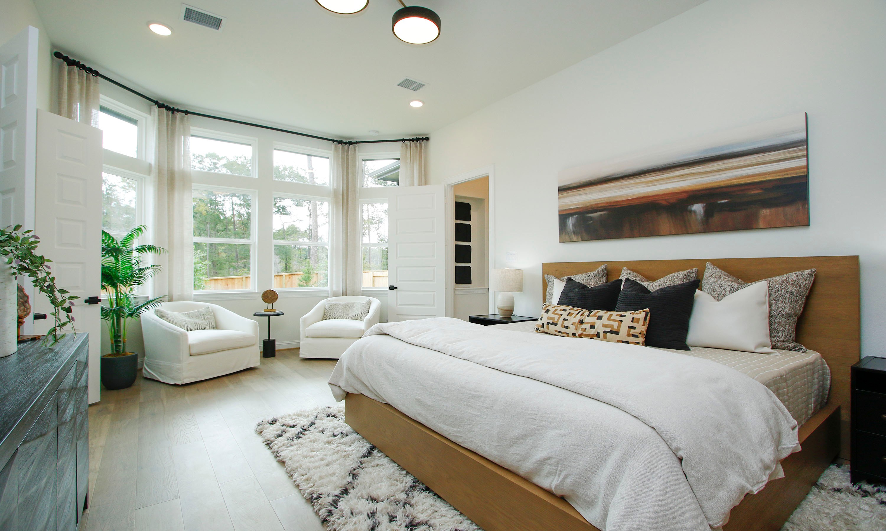 Elegant Bedroom with Bay Windows in The Woodlands Hills Community Spacious bedroom with large bay windows, modern decor, The Woodlands Hills. Neutral tones, plush textures, elegant layout.