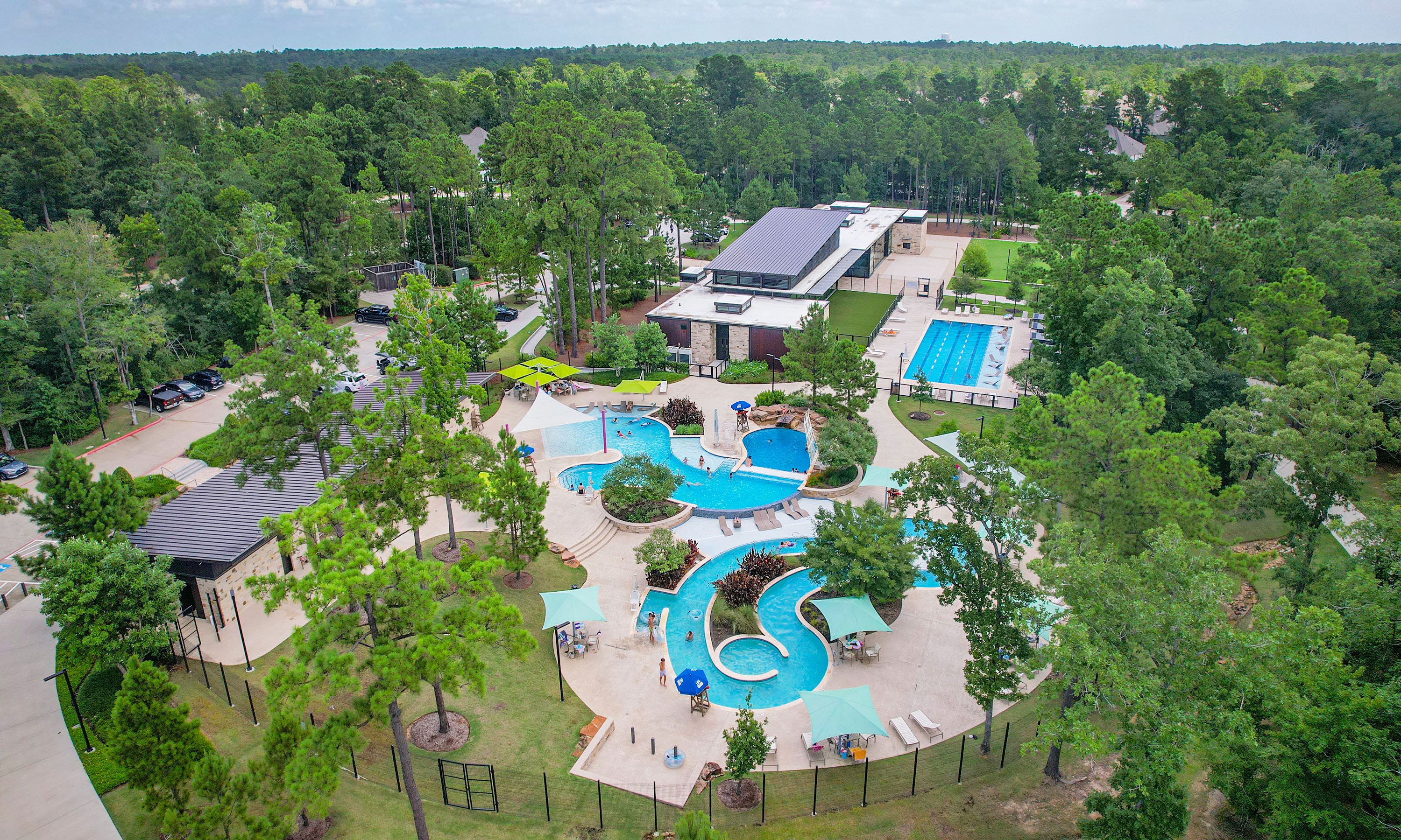 Luxury Pool Complex in The Woodlands Hills, Texas Real Estate Aerial view of luxury pool complex, surrounded by lush trees, in The Woodlands Hills, Texas. Modern design, natural setting.