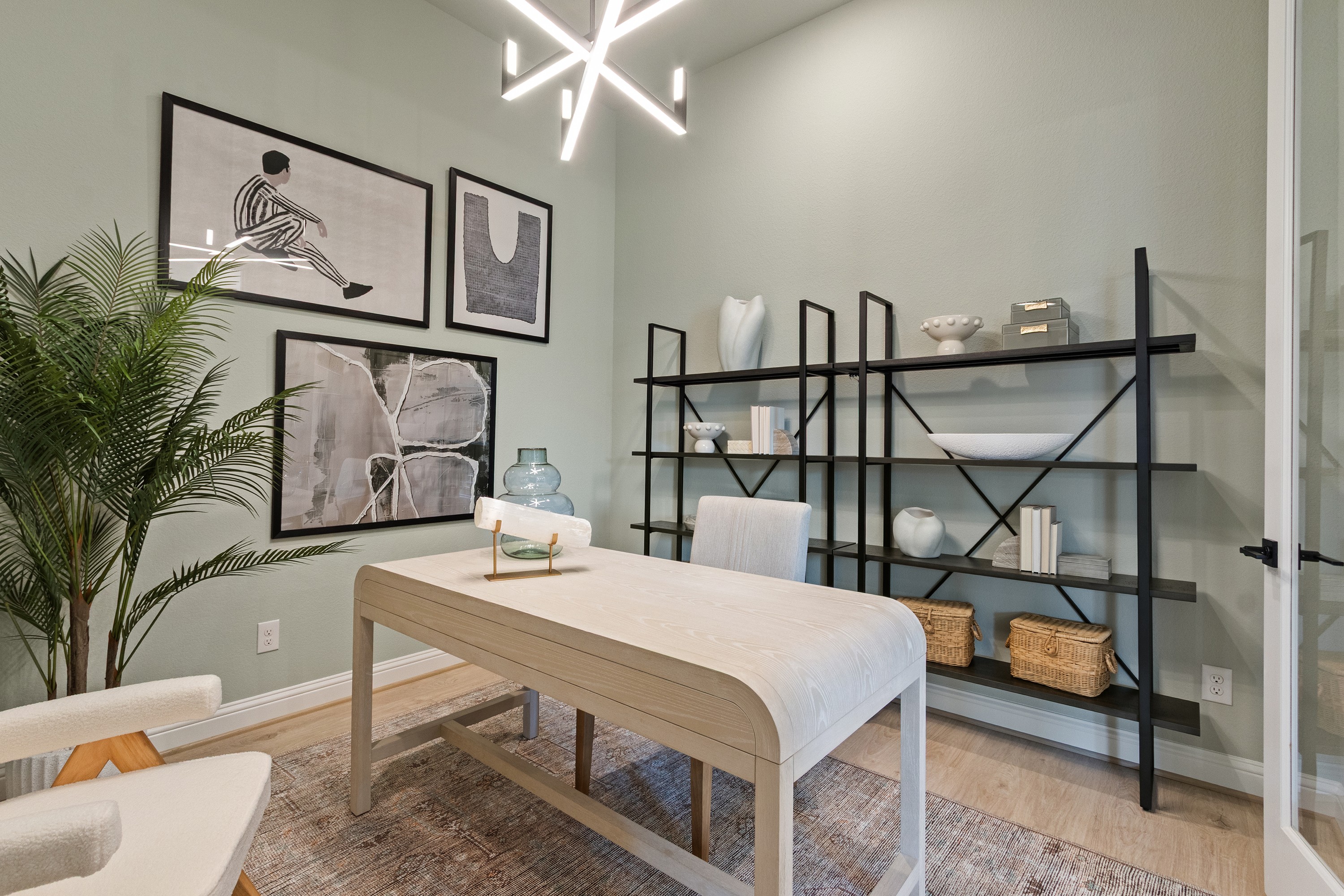 Oakwood Estates Modern Home Office with Abstract Art and Light Fixture Modern home office with light wood desk, abstract art, geometric light fixture, Oakwood Estates.