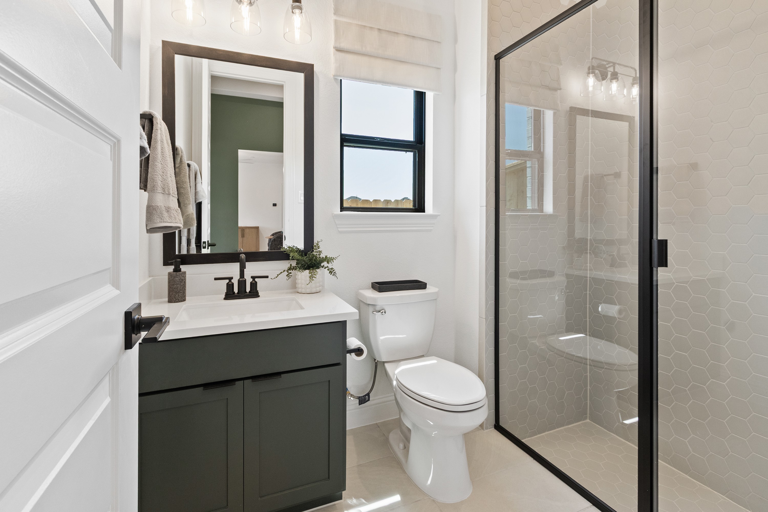 Modern Bathroom with Hex Tile Shower in Oakwood Estates Elegant bathroom in Oakwood Estates with hexagonal tile shower, modern fixtures, and stylish vanity.