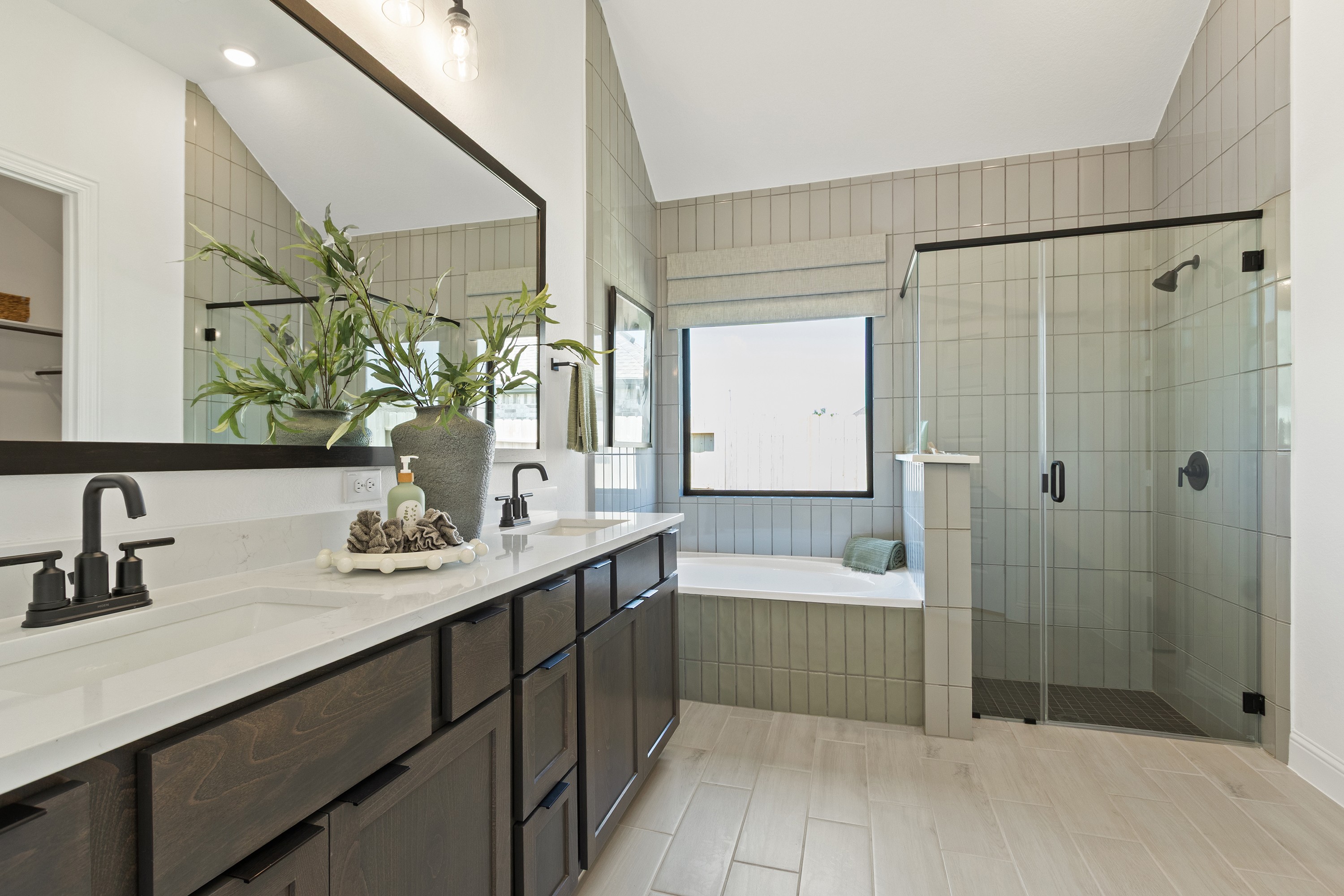 Luxury Bathroom with Dual Sinks and Glass Shower in Oakwood Estates Elegant bathroom with dual sinks, glass shower, and soaking tub. Dark wood cabinetry, Oakwood Estates.