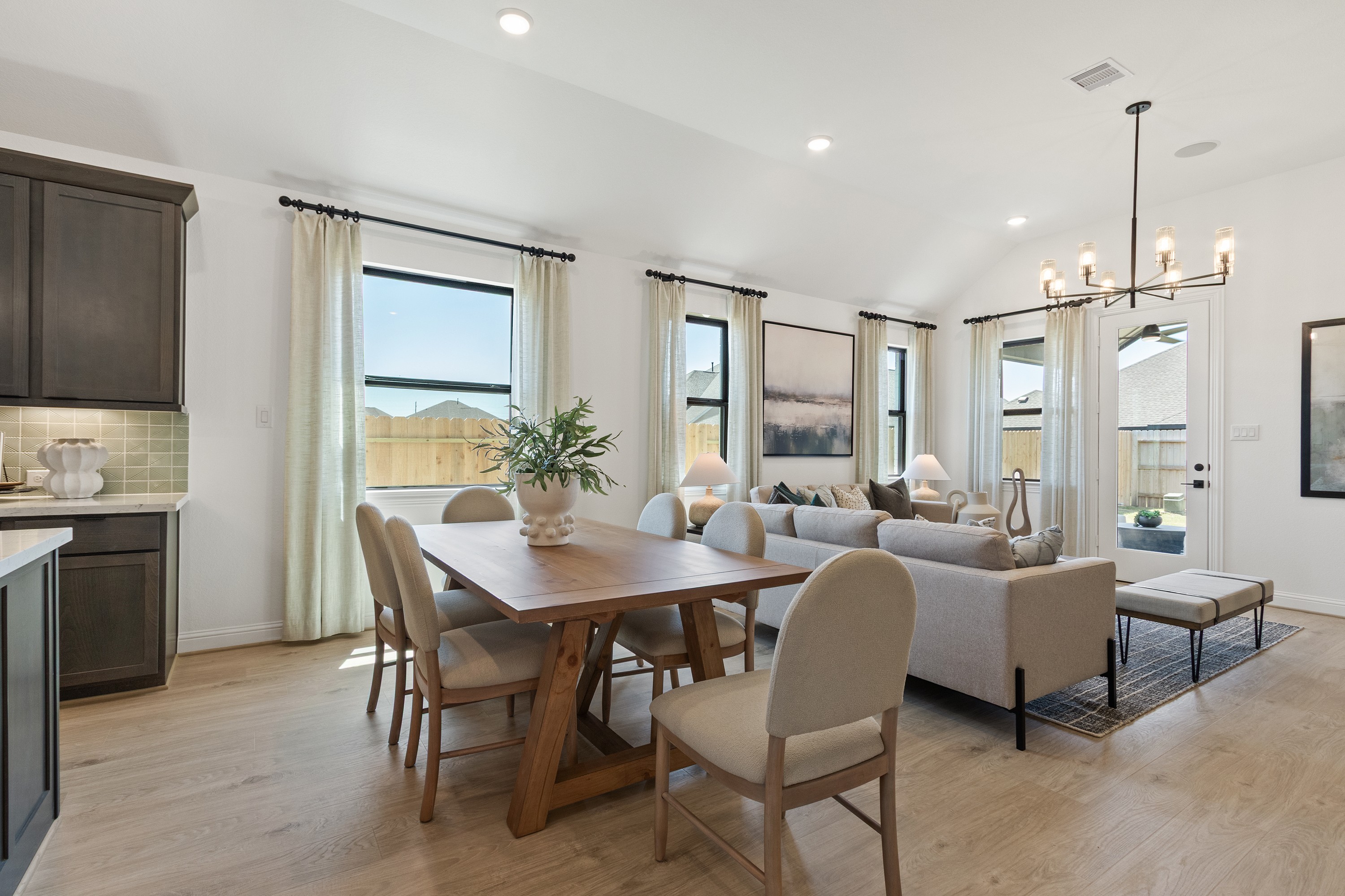 Open-Concept Living Room with Modern Chandelier in Oakwood Estates Spacious open-concept living room with light decor, modern chandelier in Oakwood Estates.
