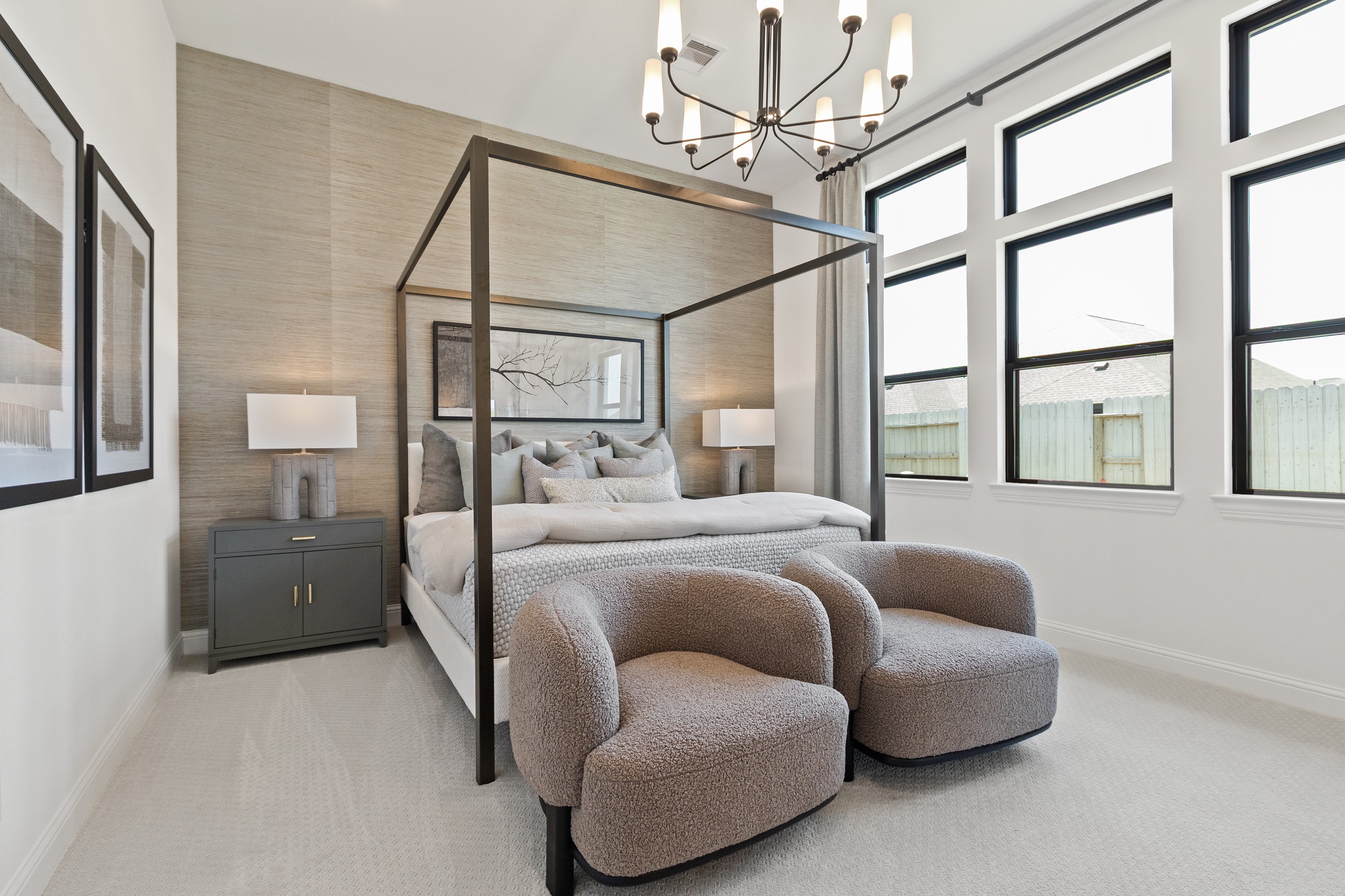 Luxurious Bedroom Design in Oakwood Estates Luxurious bedroom with canopy bed, plush chairs, modern chandelier, and tall windows in Oakwood Estates.