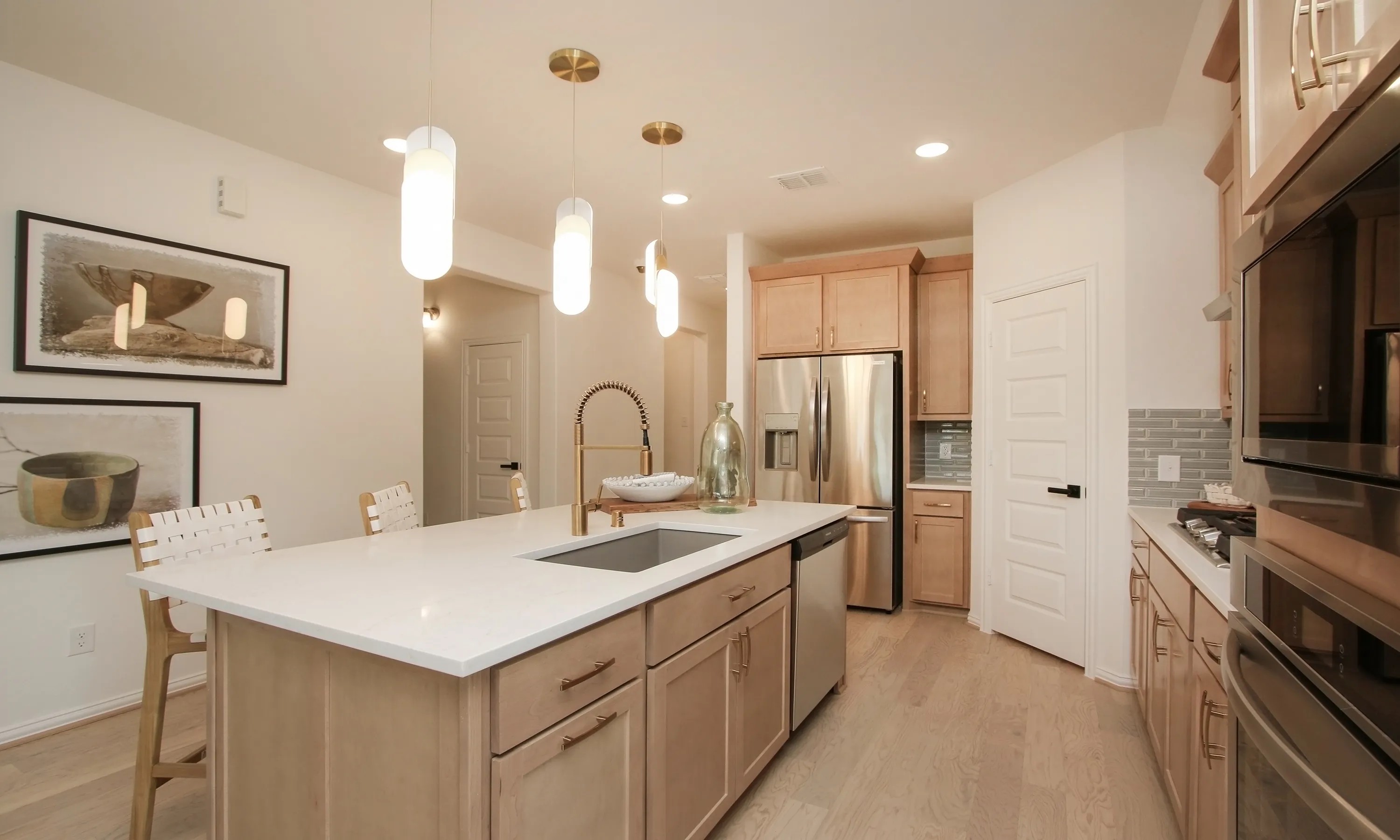 Elegant Kitchen with Island and Quartz Countertops in Ellis Cove Modern kitchen with island, quartz countertops, pendant lights, stainless steel appliances in Ellis Cove community.
