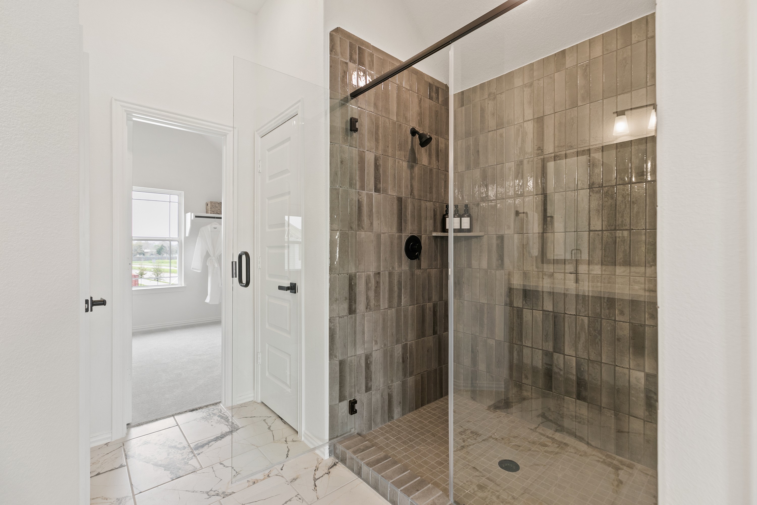 Modern Shower Design in Park at Eldridge Bathroom Modern shower with glass door and textured brown tiles in Park at Eldridge bathroom.