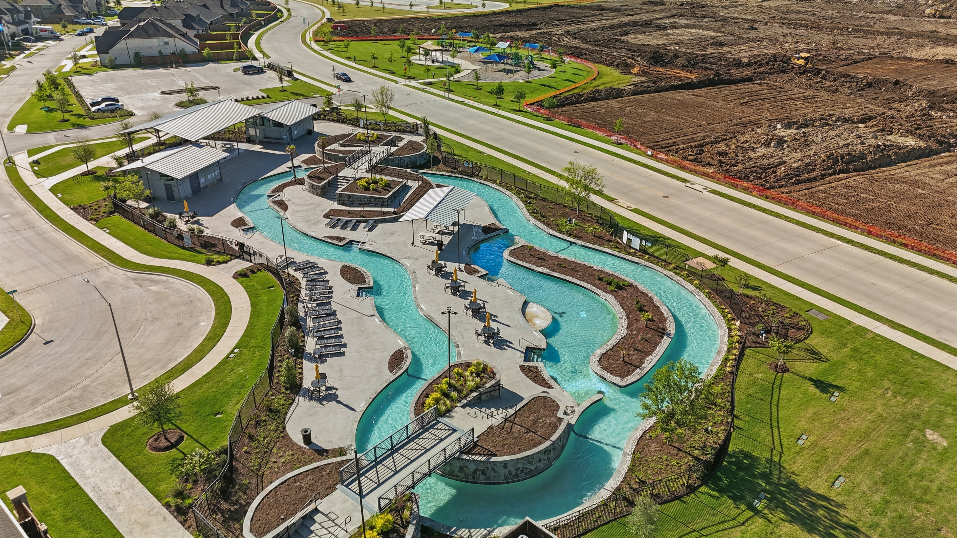 Luxury Lazy River Pool at Wildflower Ranch, Texas Aerial of luxury lazy river pool, modern architecture in Wildflower Ranch community, landscaped greenery, Texas.