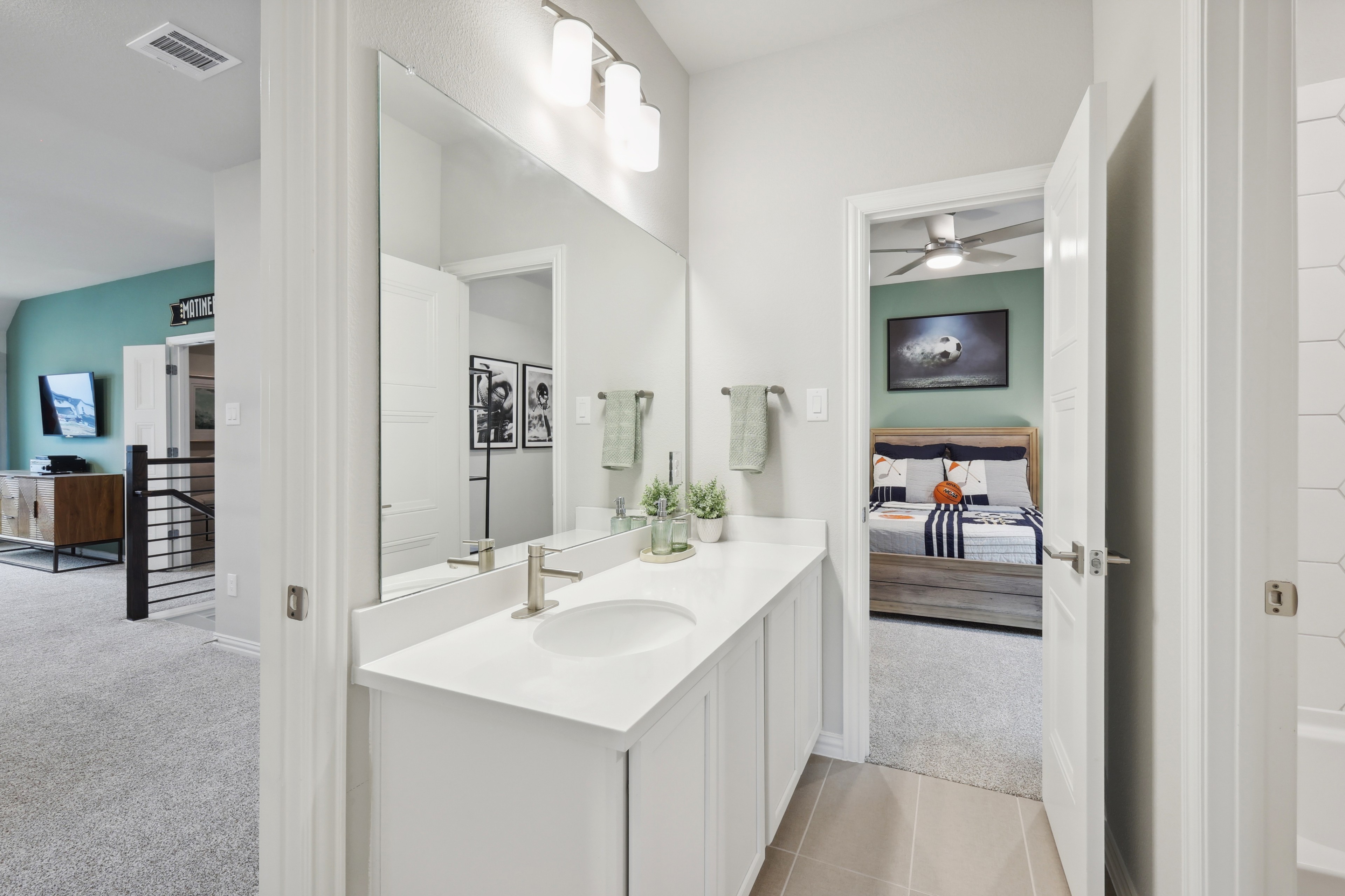Modern Bathroom and Bedroom in Wildflower Ranch Home Elegant bathroom with white vanity, large mirror, leading to stylish bedroom in Wildflower Ranch home.
