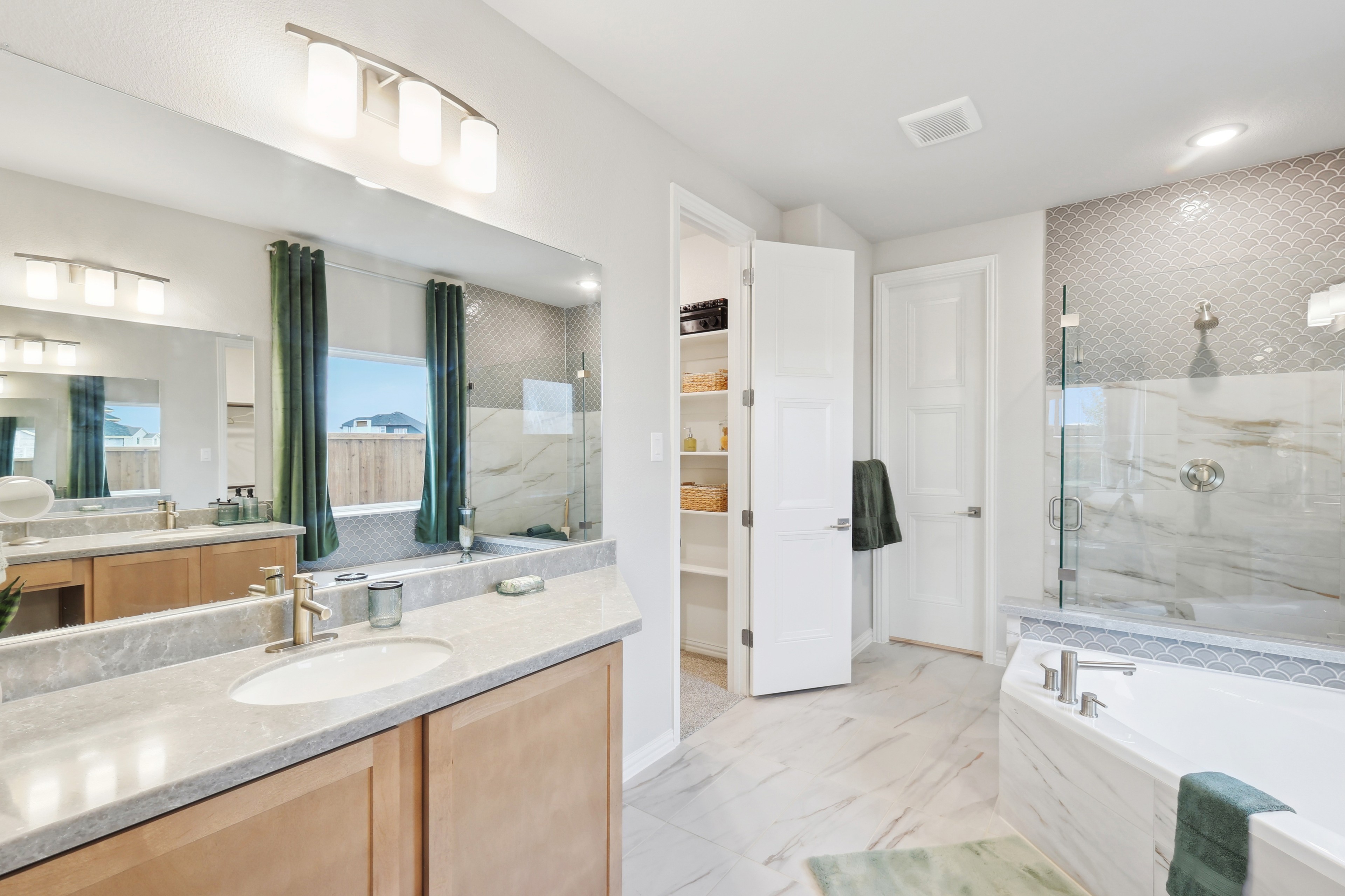 Luxurious Bathroom Design at Wildflower Ranch with Marble Features Luxurious bathroom with marble-tiled walls, spacious bathtub, large mirror, and green curtains at Wildflower Ranch.