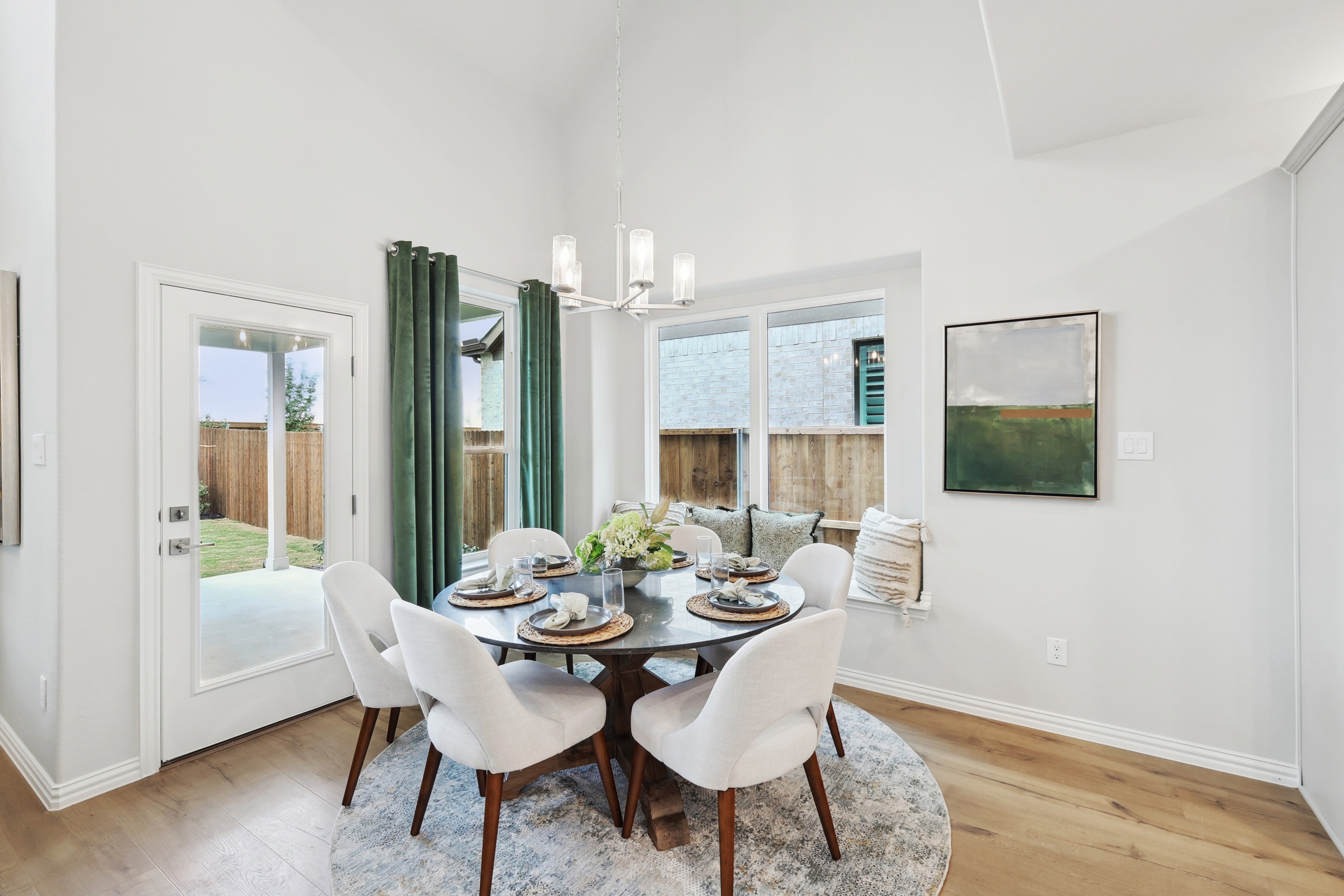 Dining Room with Chandelier in Wildflower Ranch, Texas Elegant dining area with chic chandelier, round table, and plush chairs in Wildflower Ranch, Texas. Airy and bright.