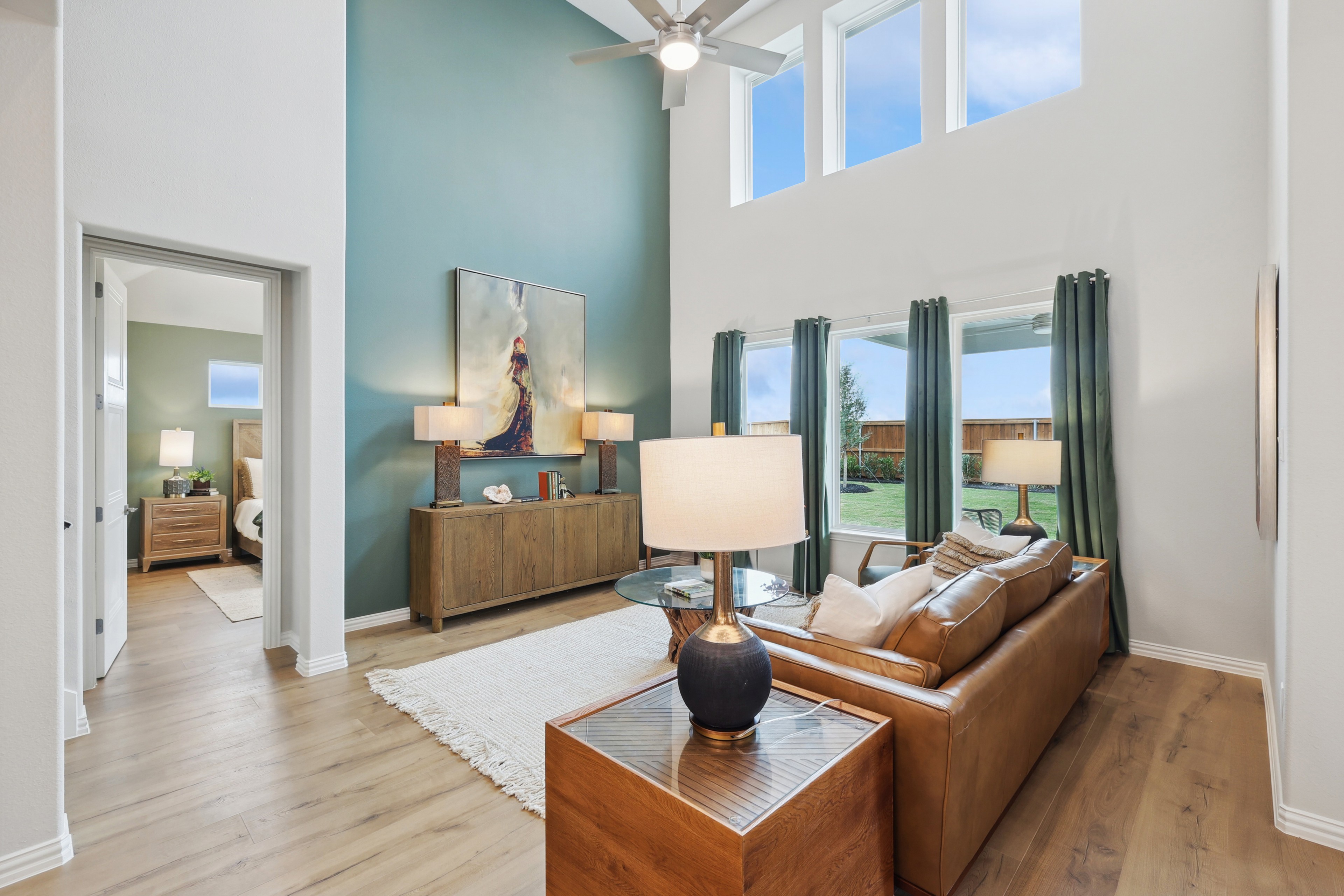 Elegant Living Room at Wildflower Ranch, Texas with Modern Decor Spacious living room with high ceilings, modern decor, large windows, leather sofa, in Wildflower Ranch, Texas.