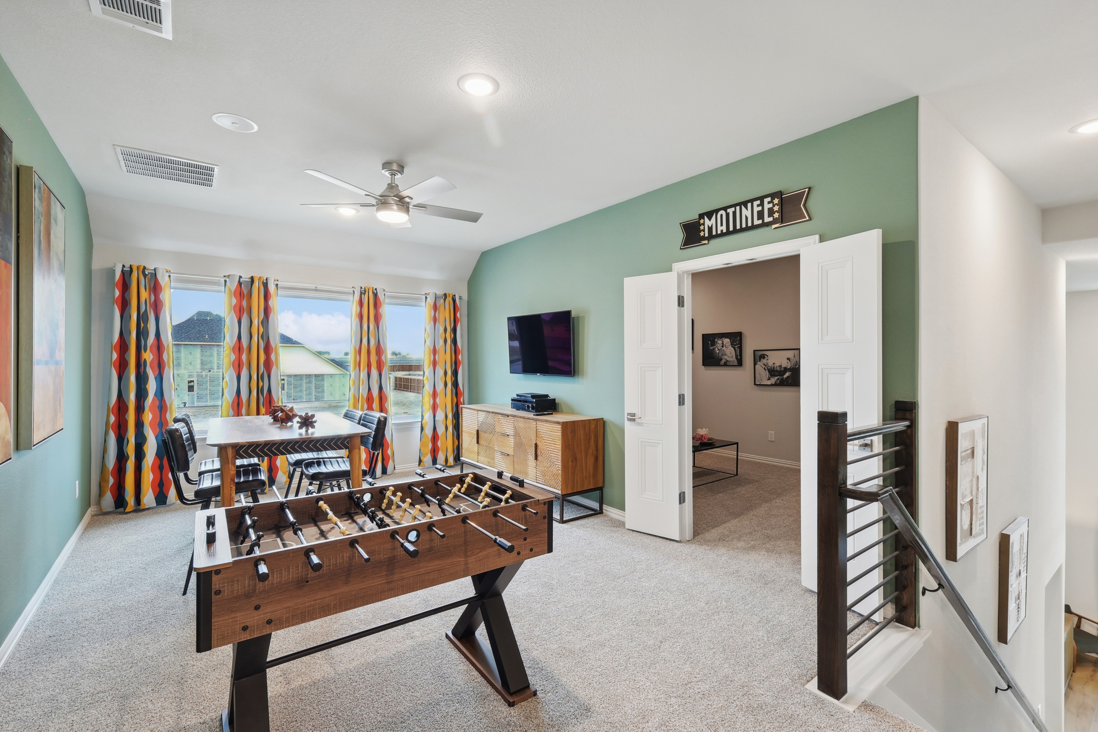Game Room at Wildflower Ranch with Foosball and TV Setup Game room with foosball, TV, green accent wall, colorful curtains, Wildflower Ranch.