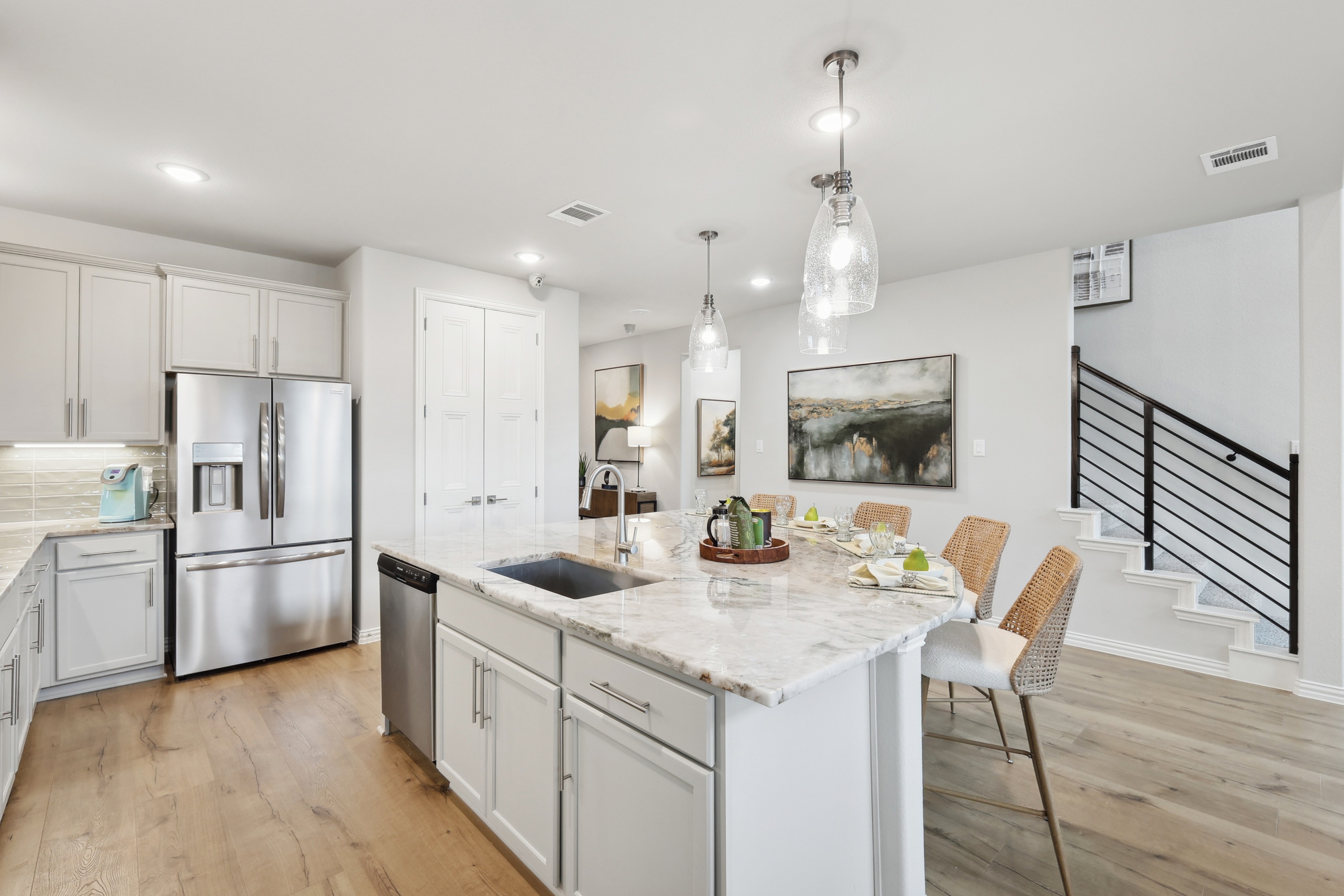 Modern Kitchen with Marble Island in Wildflower Ranch Community Modern kitchen with marble island, stainless appliances, elegant lighting; Wildflower Ranch community.
