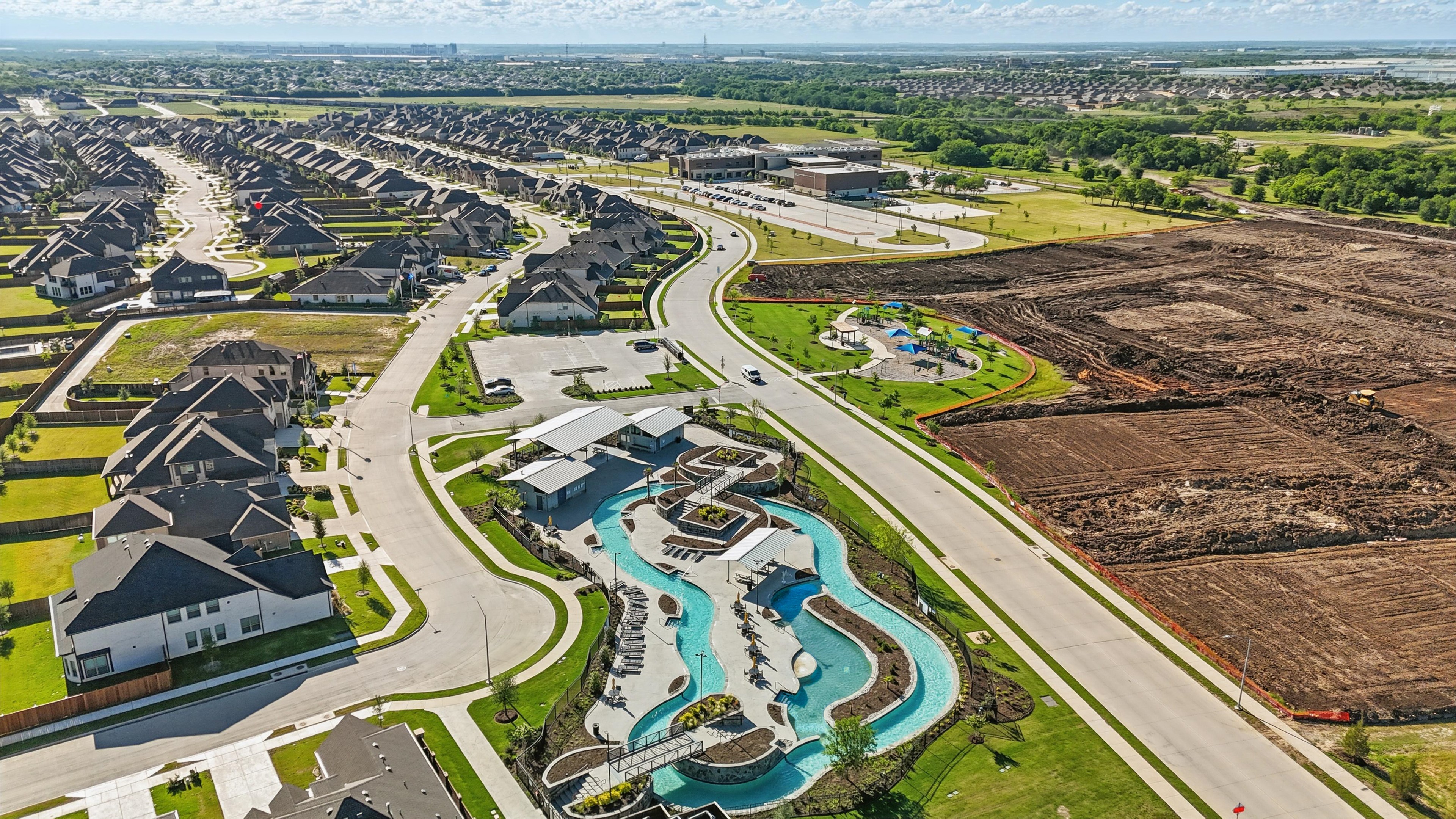 Aerial View of Luxury Wildflower Ranch Community in Texas Luxury Wildflower Ranch aerial view, featuring winding roads, modern homes, community pool, park, and open land. Texas.