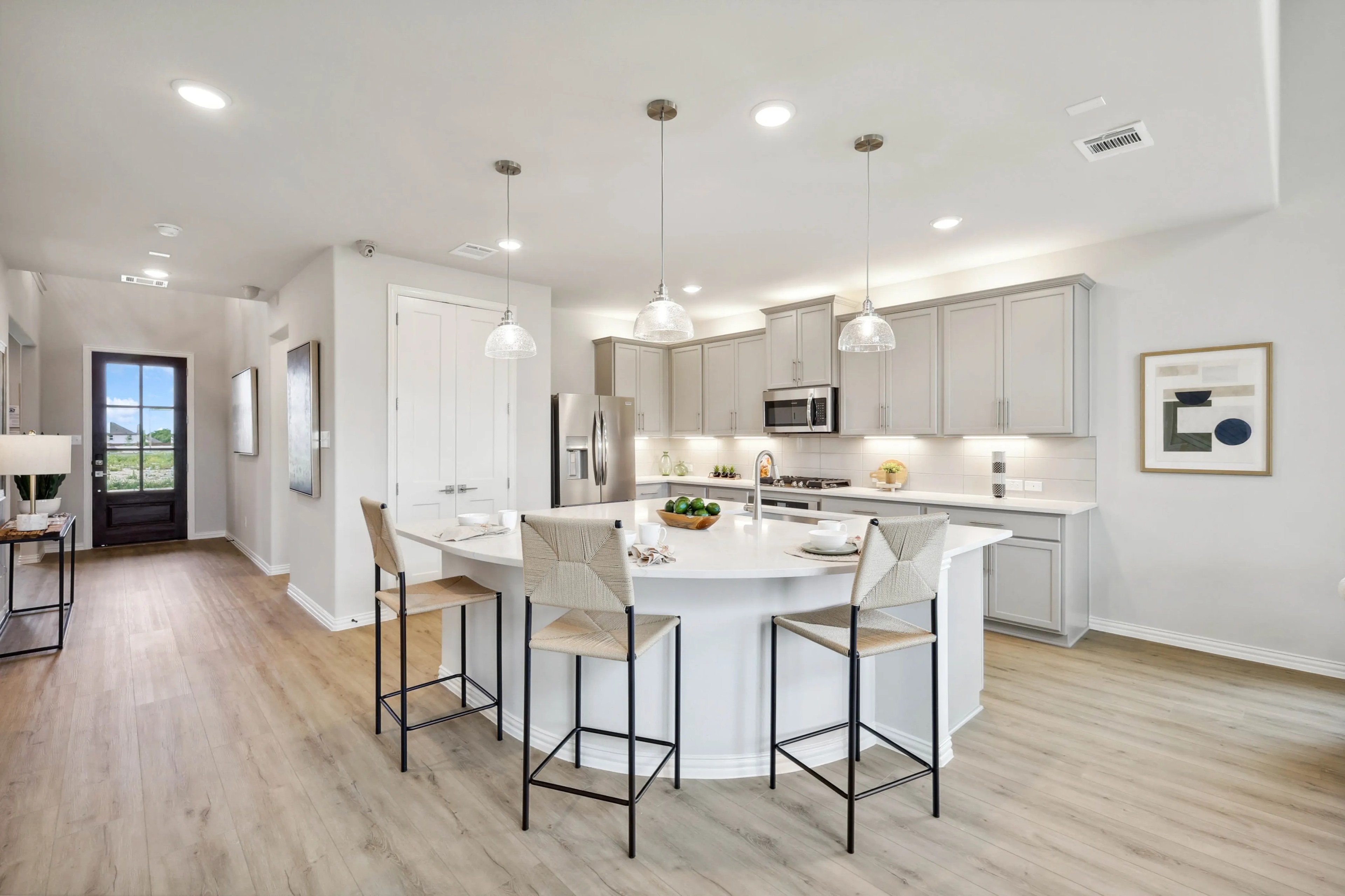Modern Kitchen Design at Hulen Trails, Fort Worth Modern kitchen with island, pendant lights, gray cabinets, wood floor. Hulen Trails, Fort Worth.