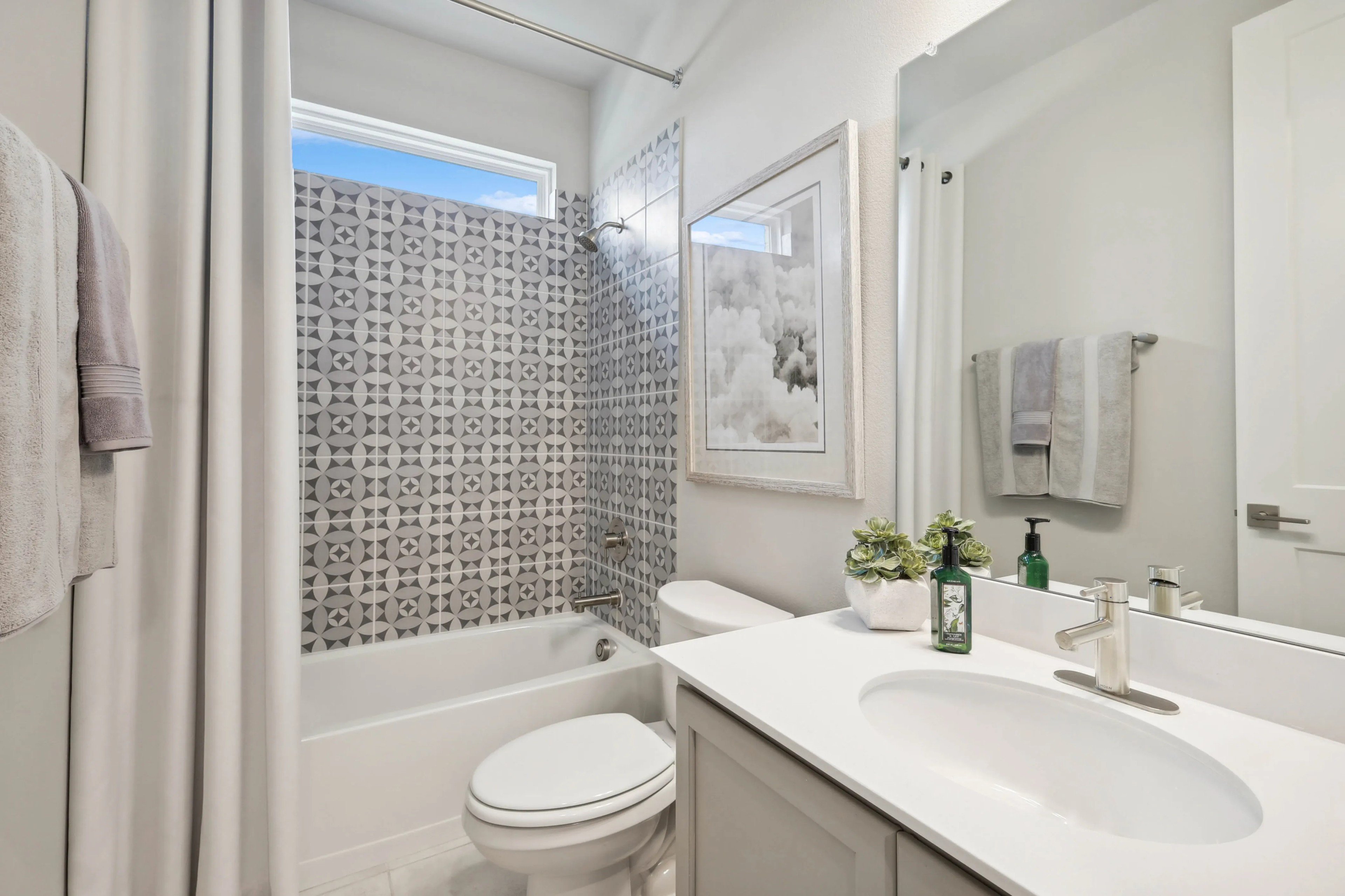 Elegant Bathroom with Geometric Tile in Hulen Trails Modern bathroom with geometric tile, framed artwork, and white fixtures in Hulen Trails.