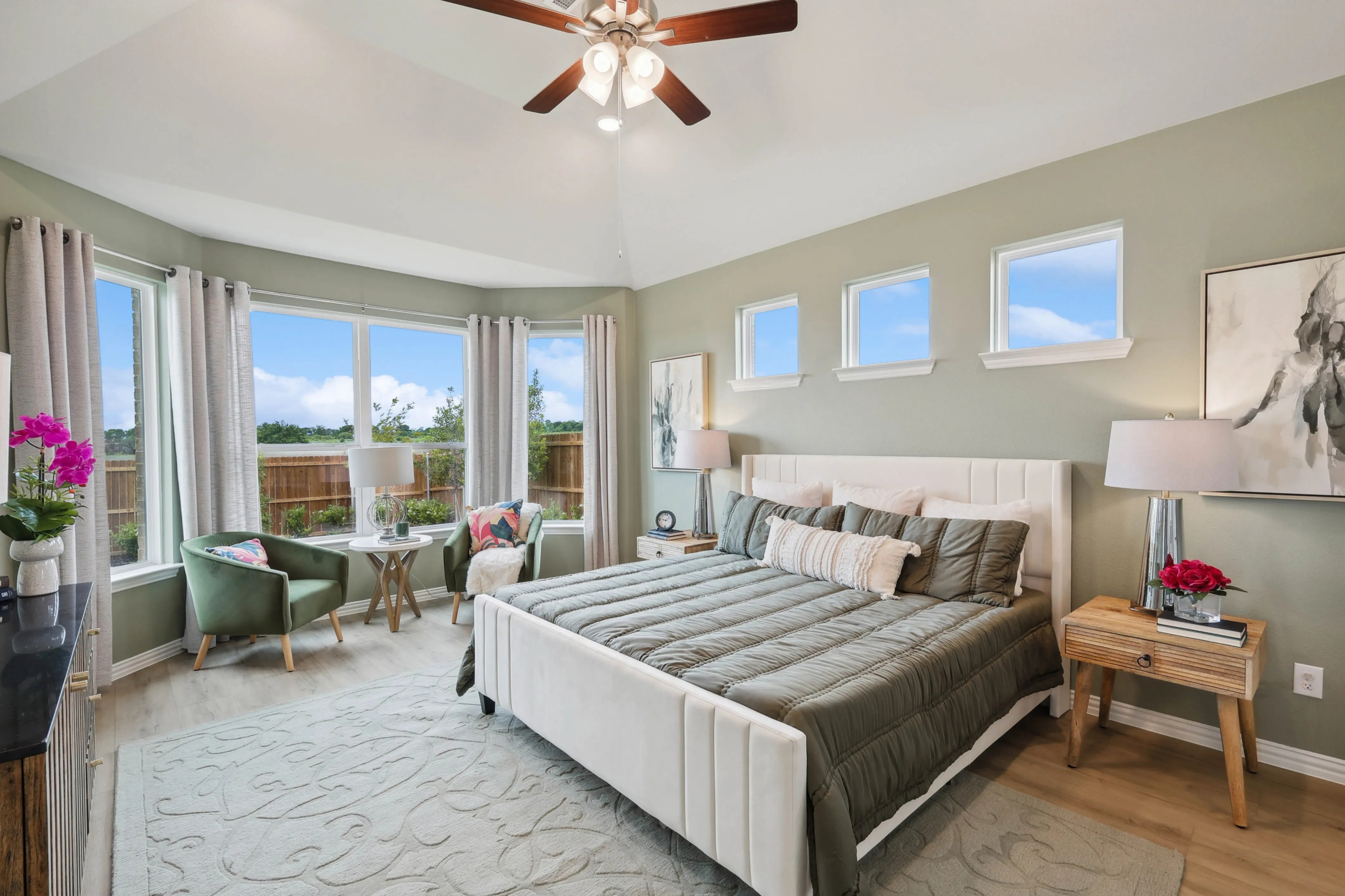 Elegant Bedroom with Bay Windows in Hulen Trails Elegant bedroom in Hulen Trails, features vaulted ceiling, large bay windows, stylish furniture, serene view.