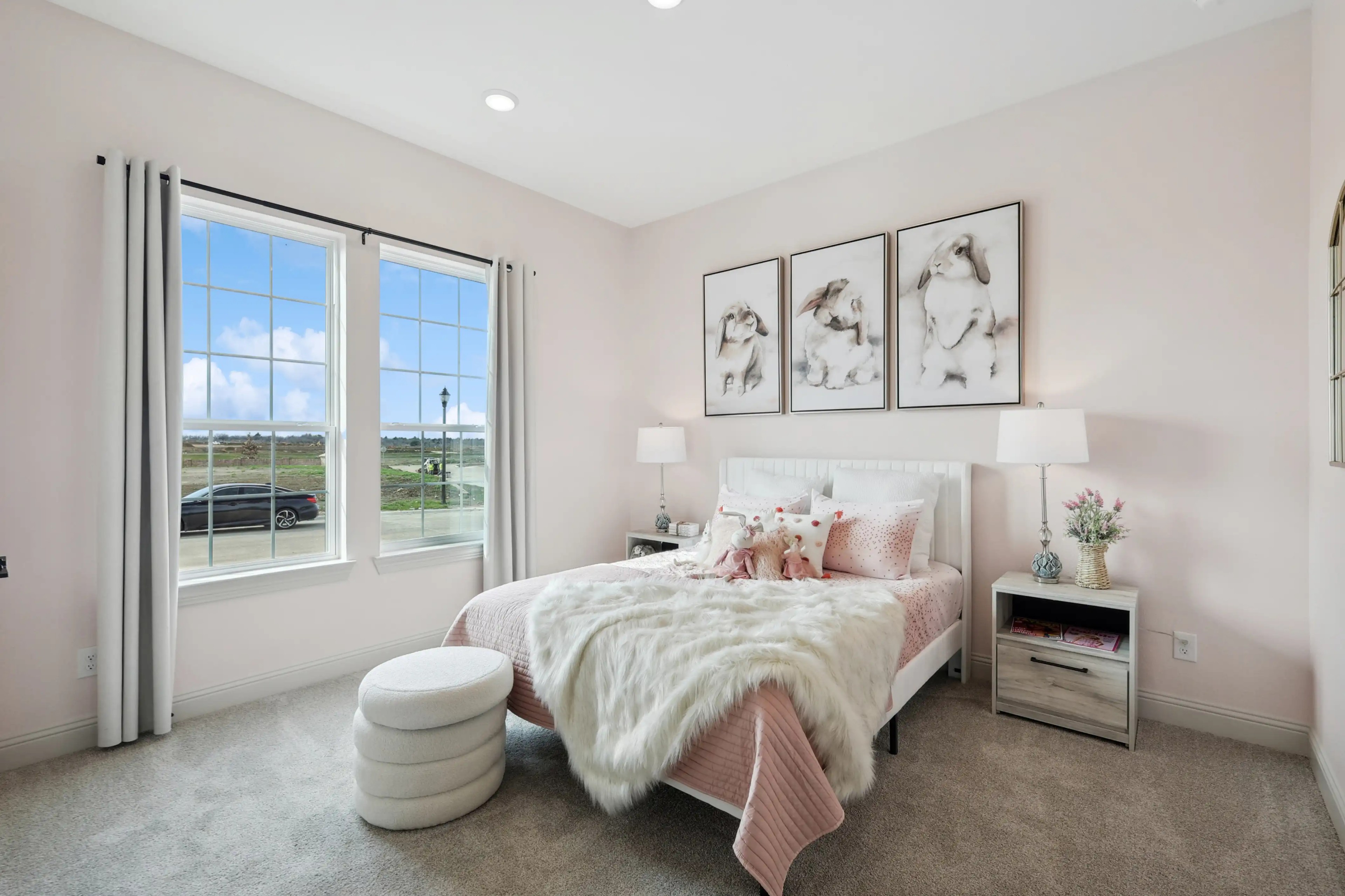 Luxurious Bedroom Interior in Westside Preserve Community Elegant bedroom with large windows, soft pink decor, and plush bedding in Westside Preserve community.