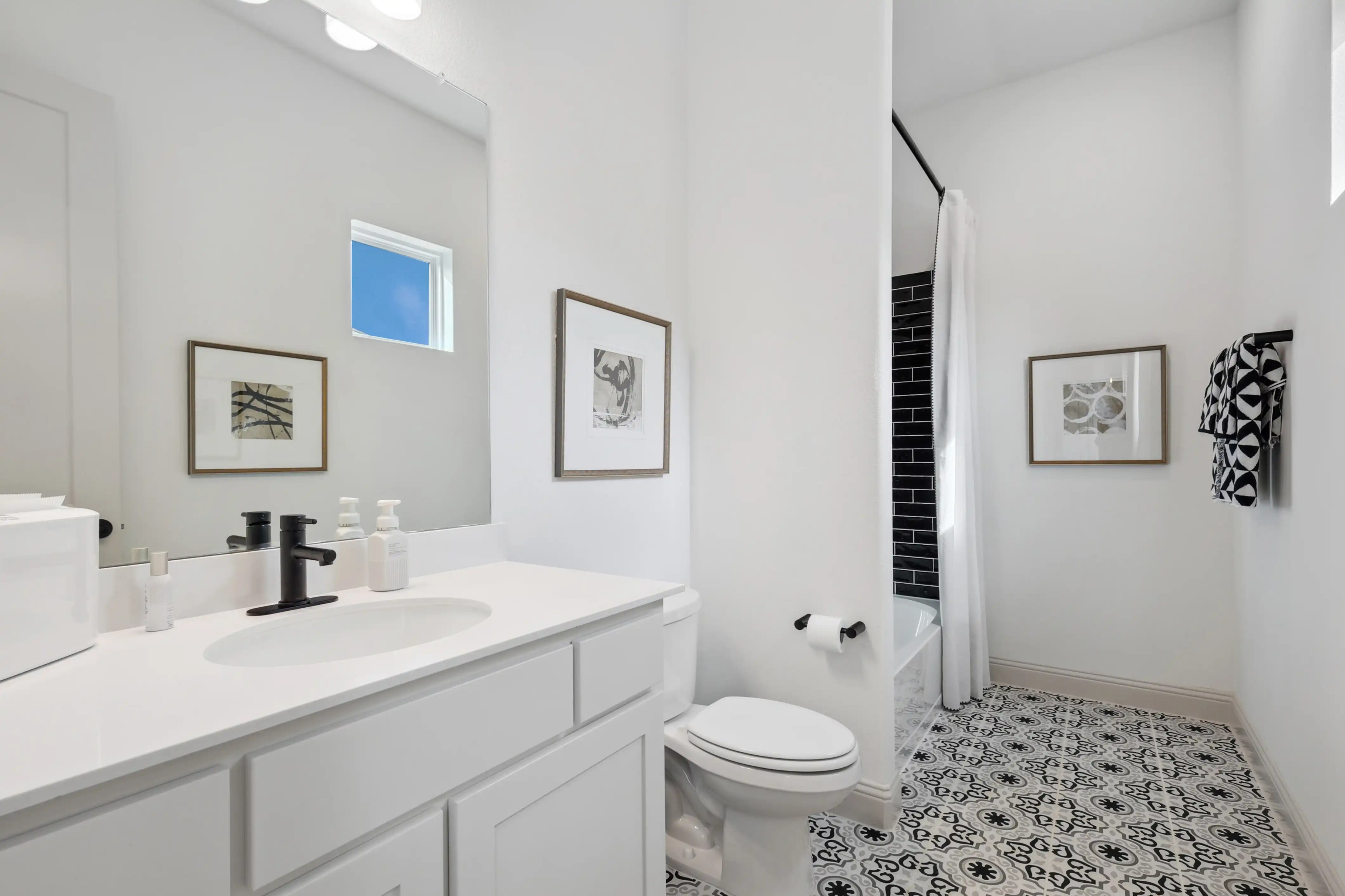 Luxurious Modern Bathroom in Westside Preserve Community Modern bathroom with black fixtures, patterned tile floor, white walls, located in Westside Preserve community.