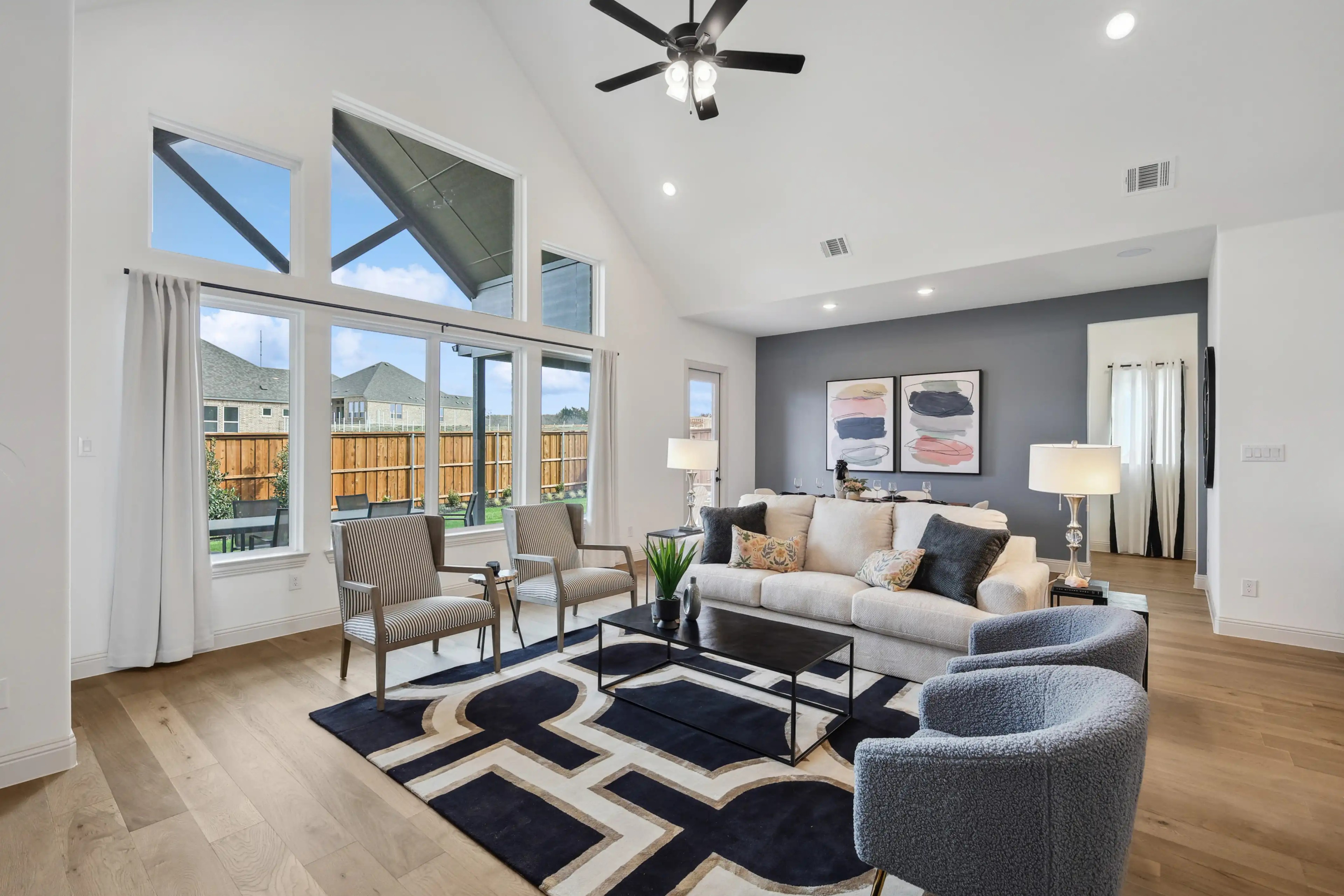 Spacious Living Room in Westside Preserve with High Ceilings and Large Windows Modern Westside Preserve living room with high ceiling, large windows, elegant decor, hardwood floors.