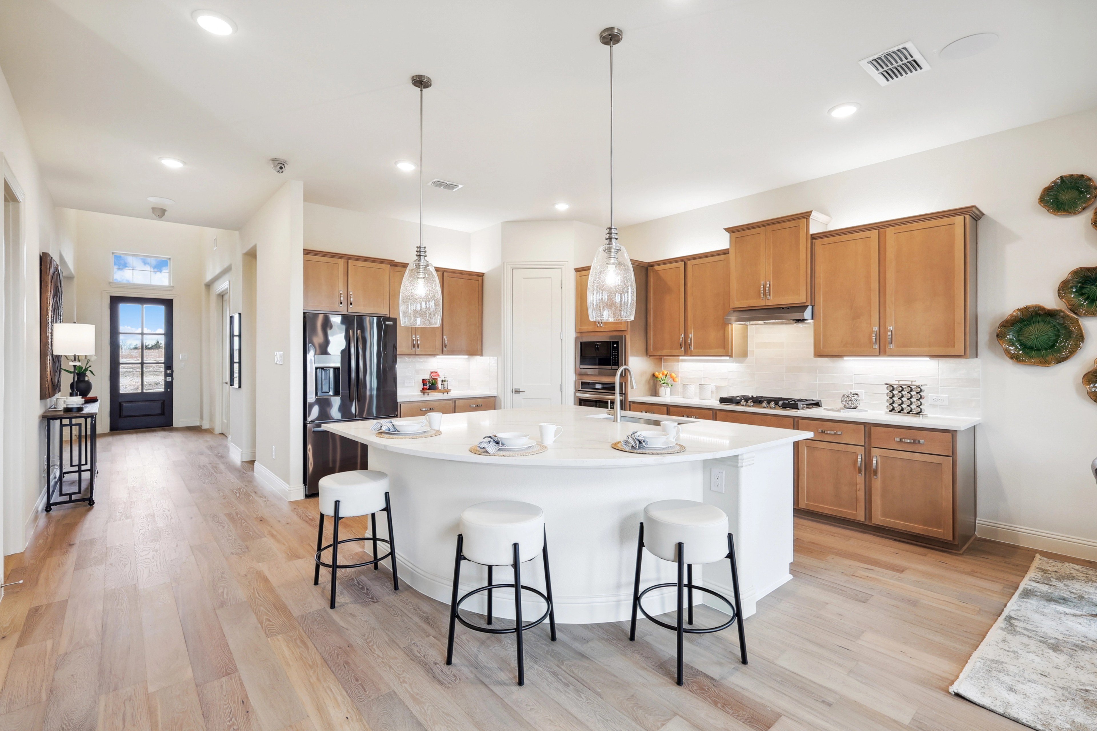 Elegant Kitchen with Center Island in The Oaks Community Modern kitchen with pendant lighting, wood floors, and center island at The Oaks community.
