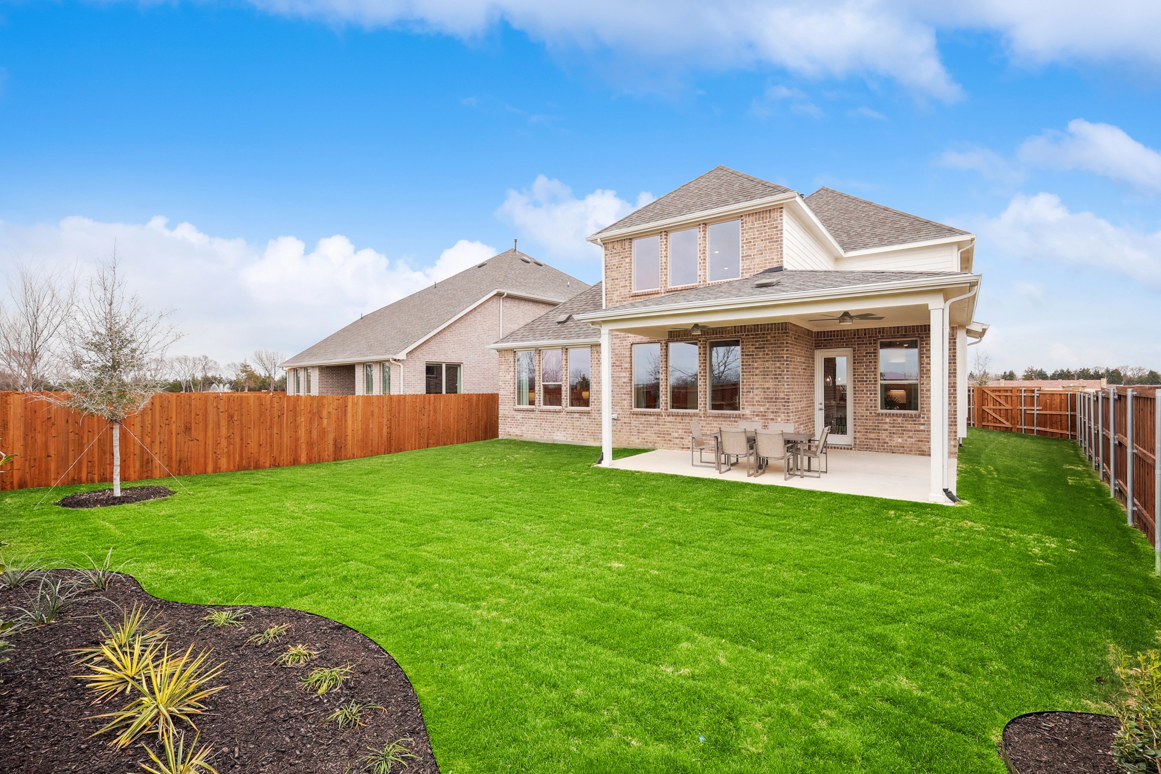 Brick House with Patio in The Oaks Community Brick house with large backyard, patio, and wooden fence in The Oaks community. Clean design, spacious exterior.