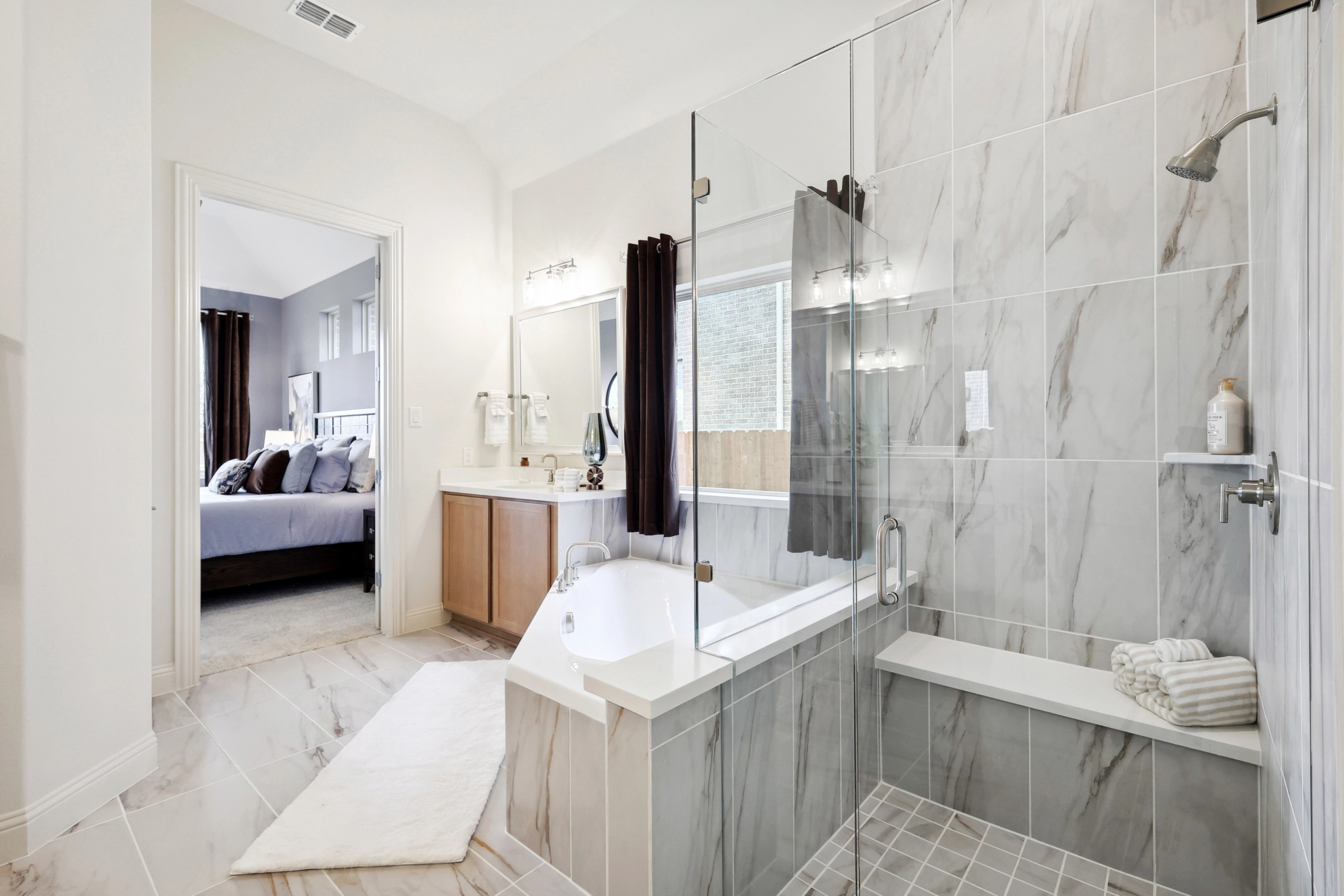Luxurious Master Bathroom with Marble Tiles in The Oaks Luxurious master bathroom featuring a glass shower, marble tiles, and freestanding tub in The Oaks community.