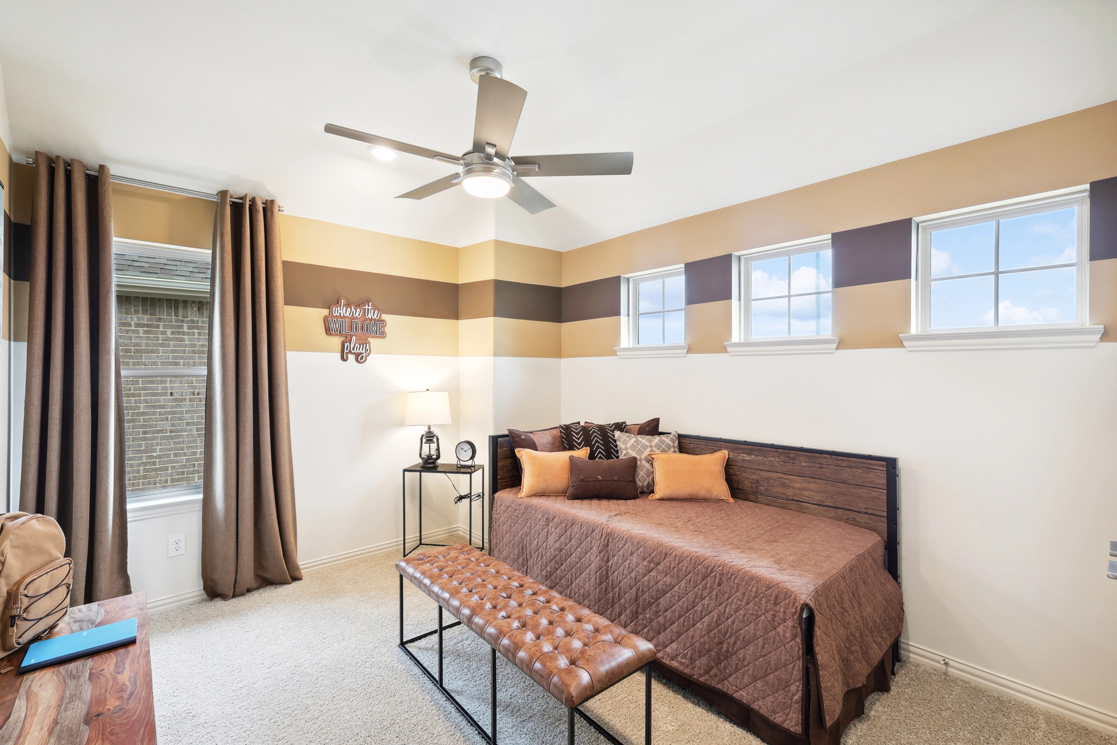 Stylish Bedroom with Modern Decor in The Oaks Cozy bedroom with striped walls, ceiling fan, and elegant decor in The Oaks community.