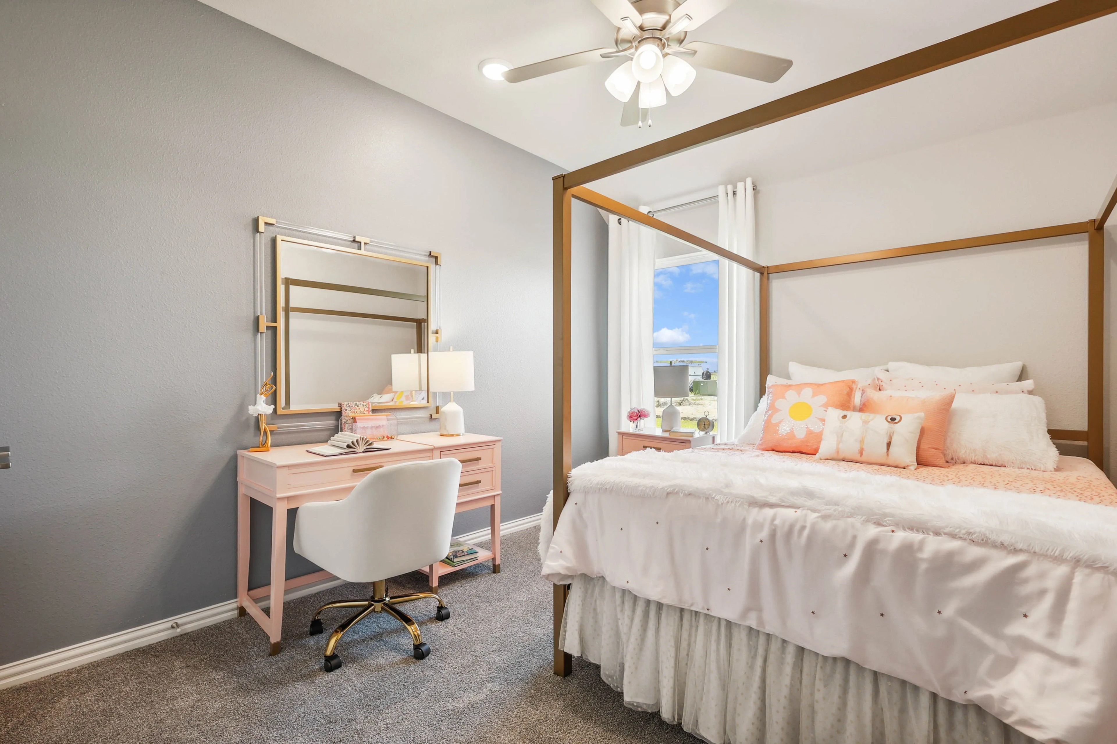 Elegant Bedroom with Plush Bedding in Pebblebrook Community Chic bedroom in Pebblebrook, with luxe pink vanity, gold mirror, plush bedding, elegant ceiling fan, abundant natural light.