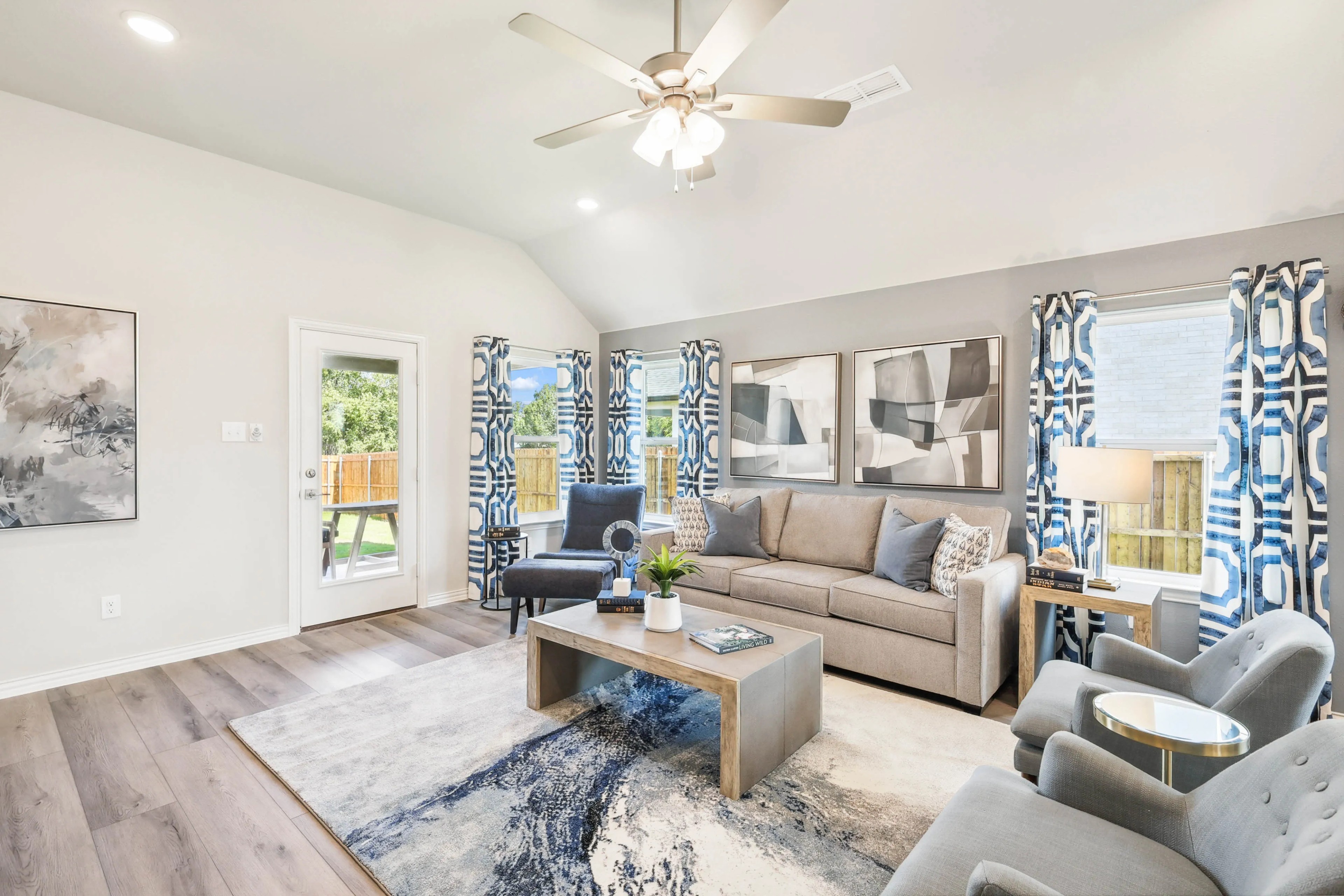 Luxurious Living Room with Geometric Decor in Pebblebrook Community Spacious living room, neutral tones, geometric decor, large windows, Pebblebrook community, elegant furniture, natural light.