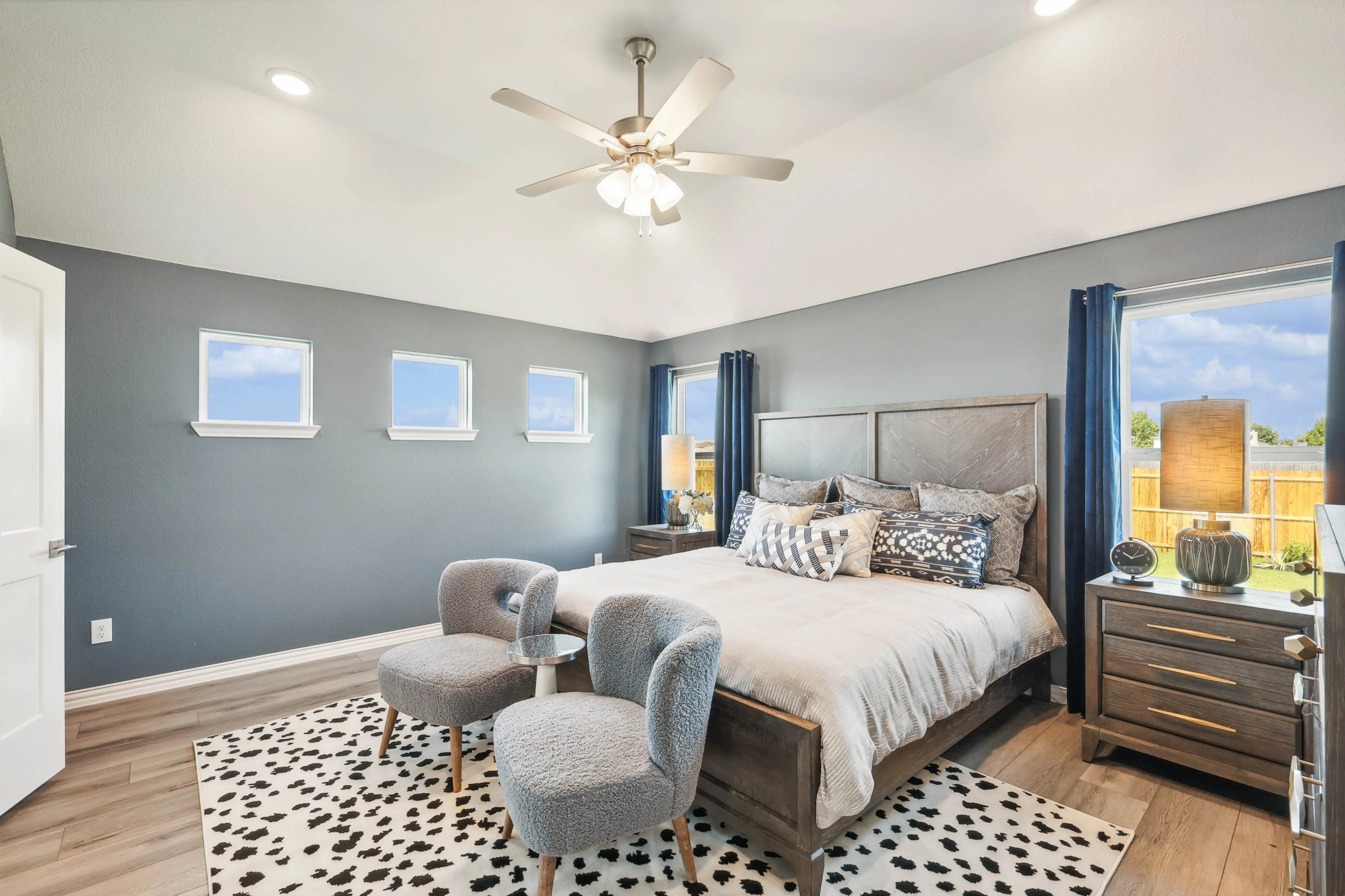 Luxurious Bedroom in Pebblebrook Community with Modern Decor Elegant bedroom with gray walls, three small windows, plush bed, and modern decor in Pebblebrook community.