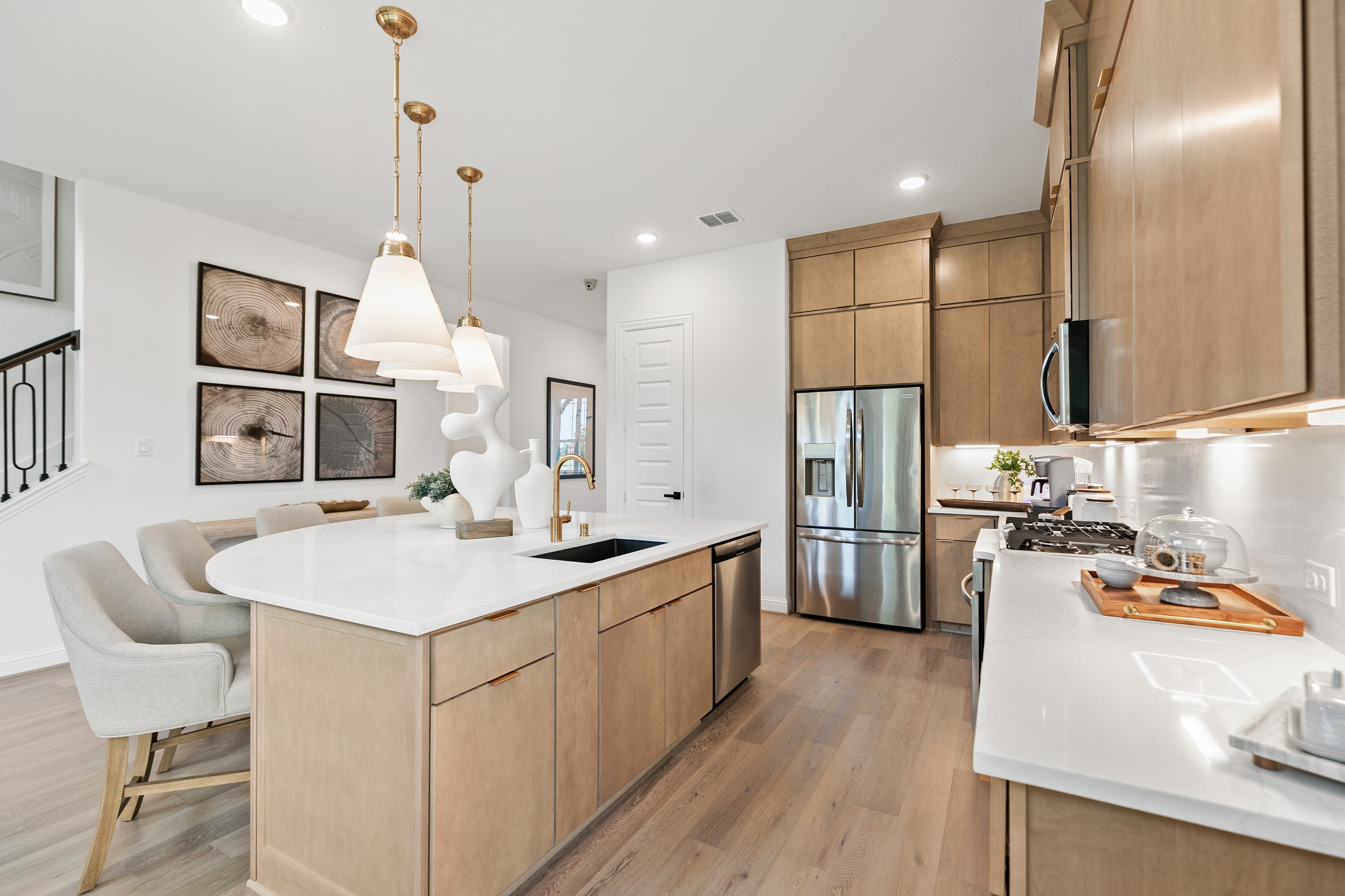 Modern Kitchen with Island and Wood Cabinets in Katy Lakes Modern kitchen with island, pendant lights, light wood cabinets in Katy Lakes home.