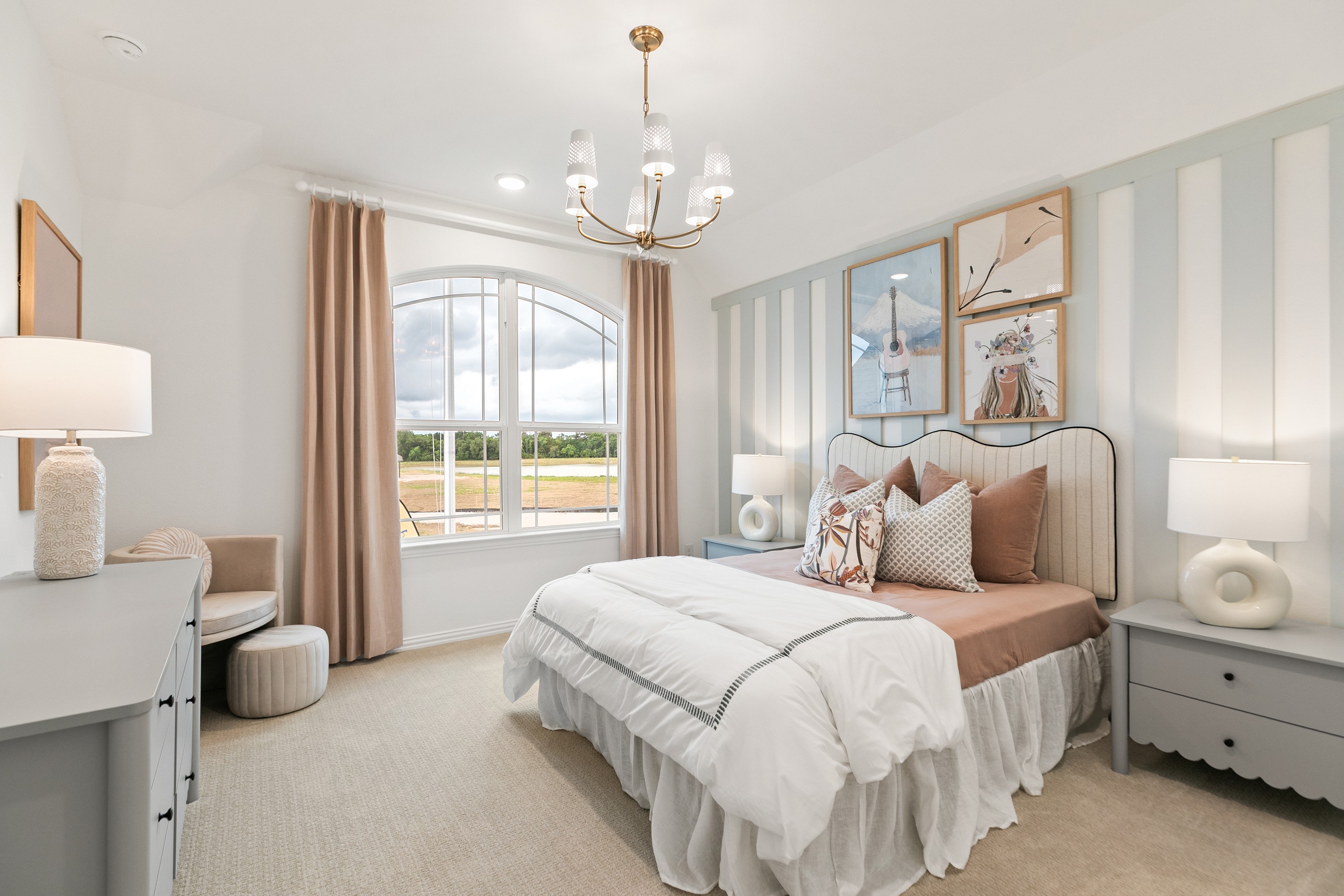 Sophisticated Bedroom with Arched Window in Katy Lakes Elegant bedroom with arched window, striped accent wall, chandelier in Katy Lakes.